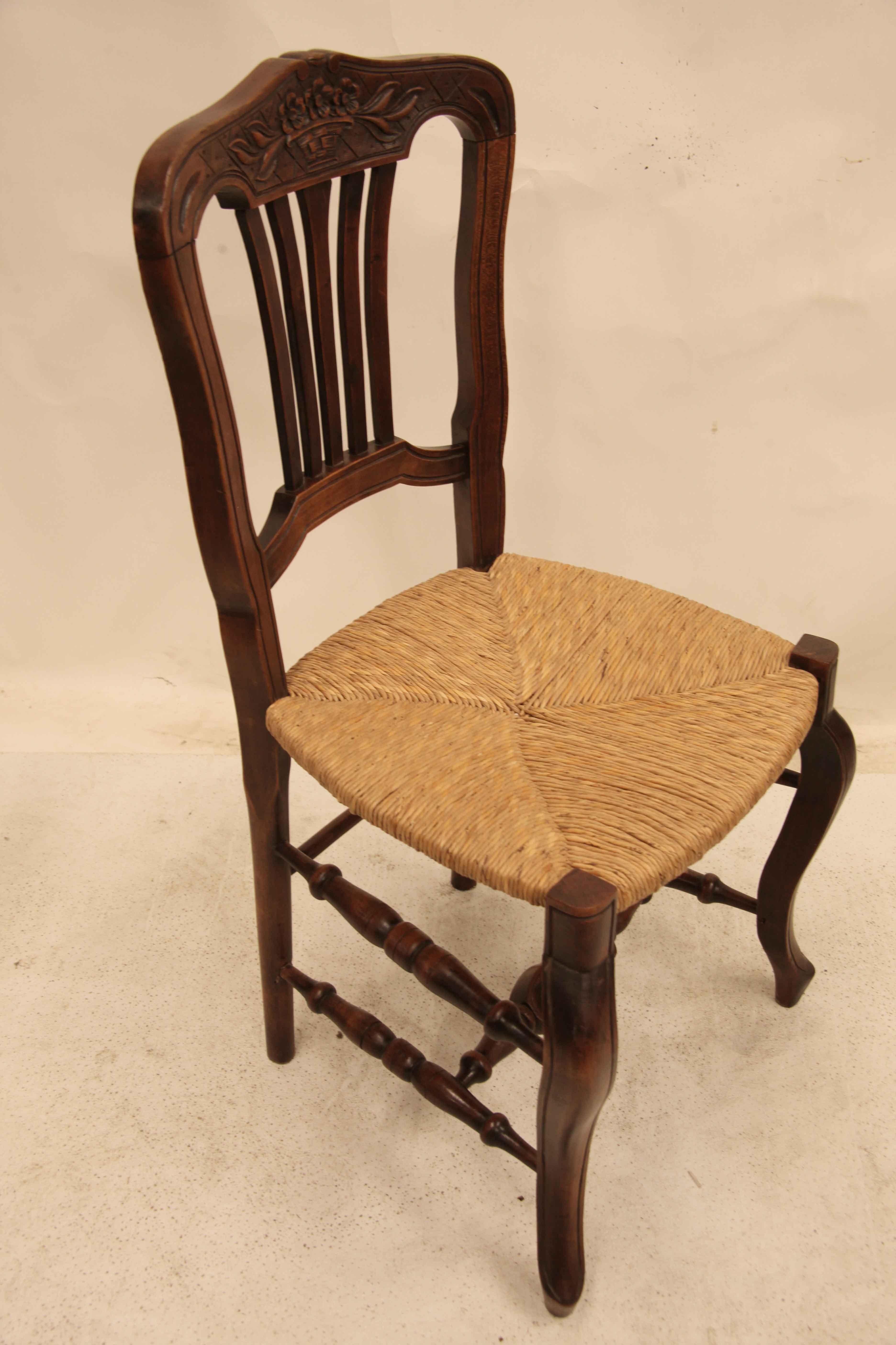 Set of six French rush bottom chairs, the concave shaped crest rail has a carved basket of three flowers with foliate extending from each end; original rush seats; front legs and back connected with double turned stretchers, the cross stretcher has