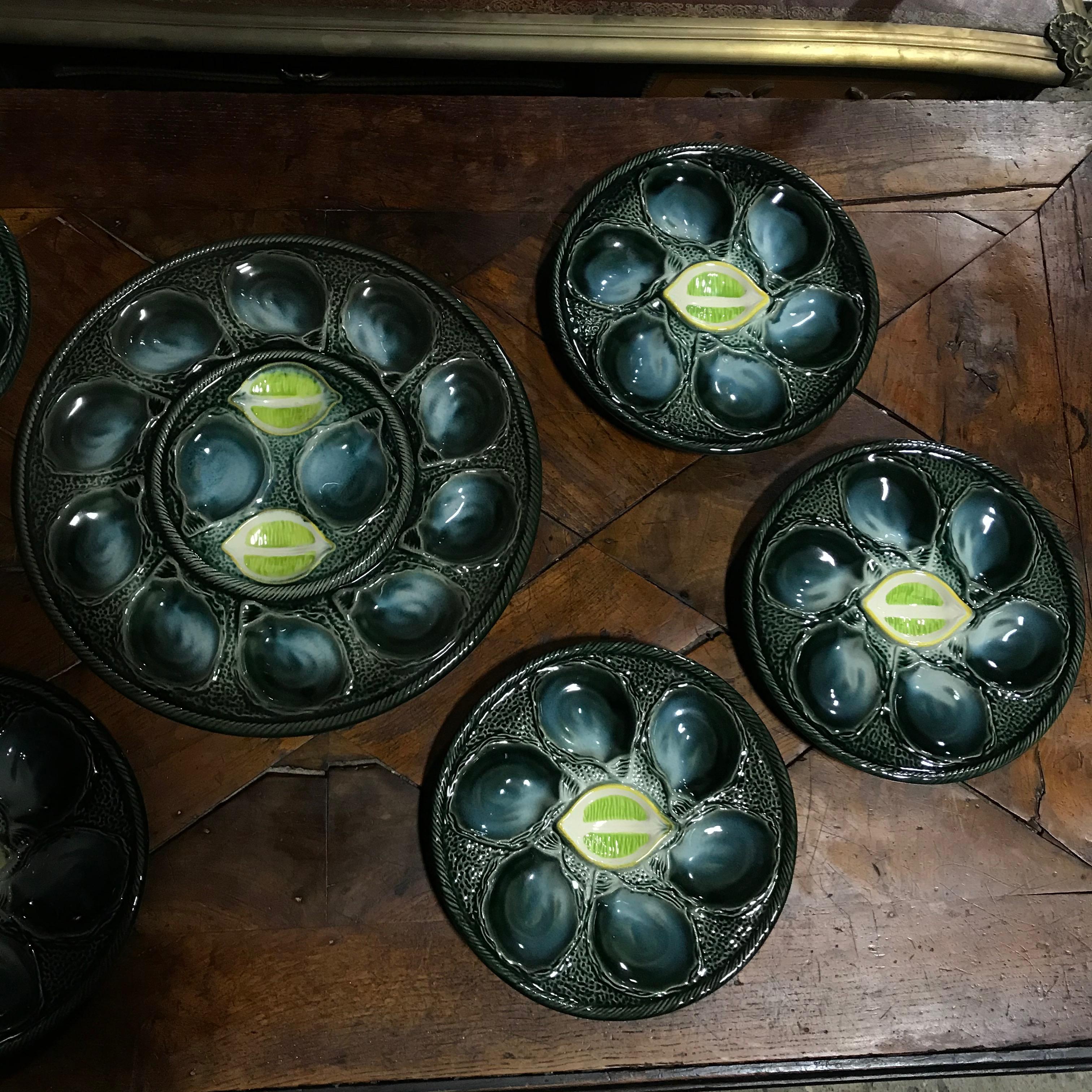 Set of six St. Clement French oyster plates with one serving platter in green painted finish with decorative lemon slots.
#3798
Measures: Diameter platter 14.5” x diameter plates 10”.