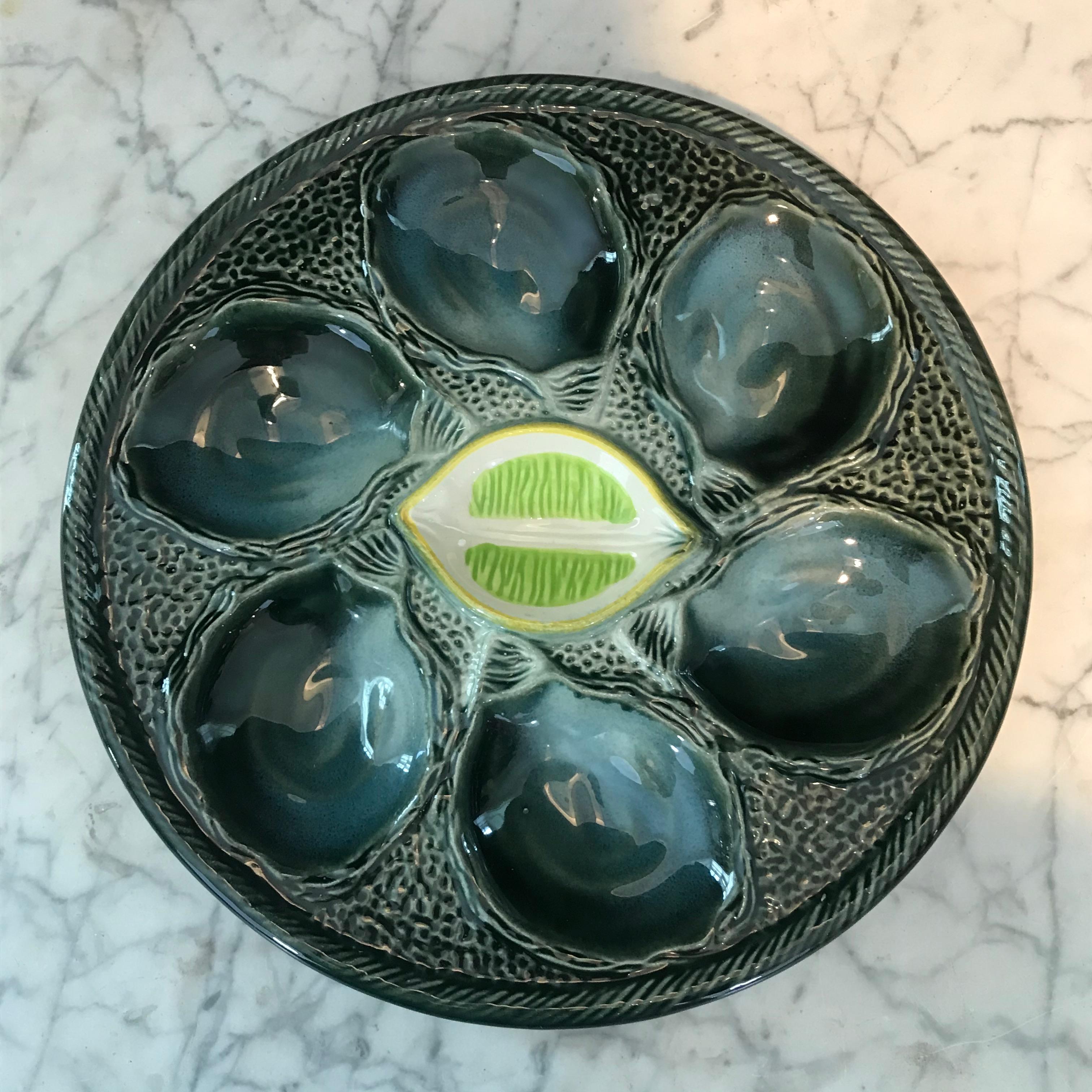 A wonderful set of 6 St. Clement vintage French Majolica oyster plates having indentations for the oysters and a real looking slice of yellow lemon in the centers.