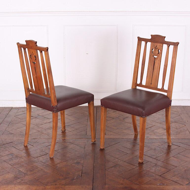 A set of six French Art Nouveau dining chairs in walnut, the backs with pierced fretwork details and square tapering front legs with flared feet. Recently-upholstered leather seats.