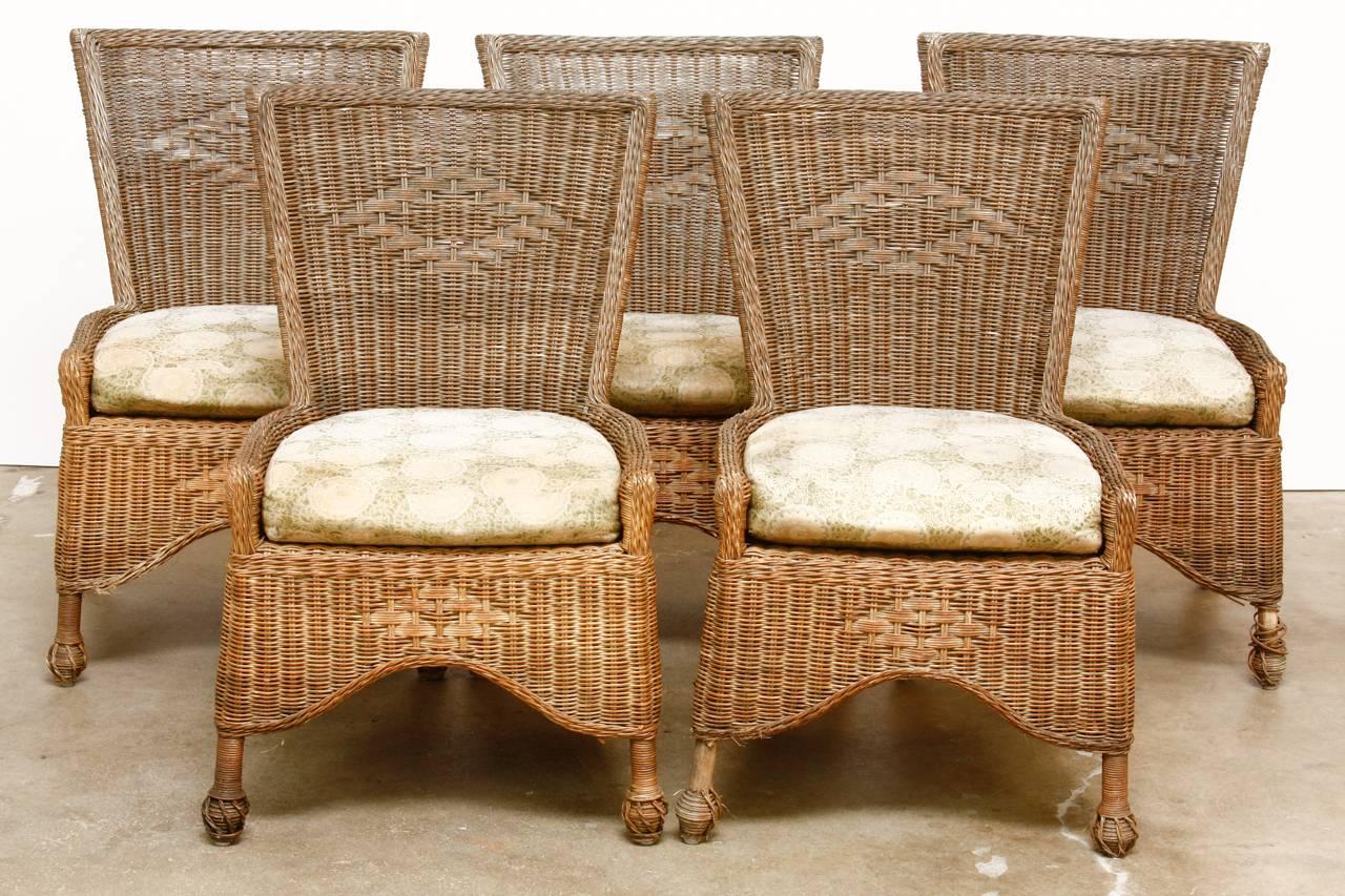 Stylish set of six country French wicker and rattan patio dining chairs. Features a square back design with serpentine seat aprons. The frames are made of bamboo and rattan then covered with natural wicker. Made in the style of Grange with each seat