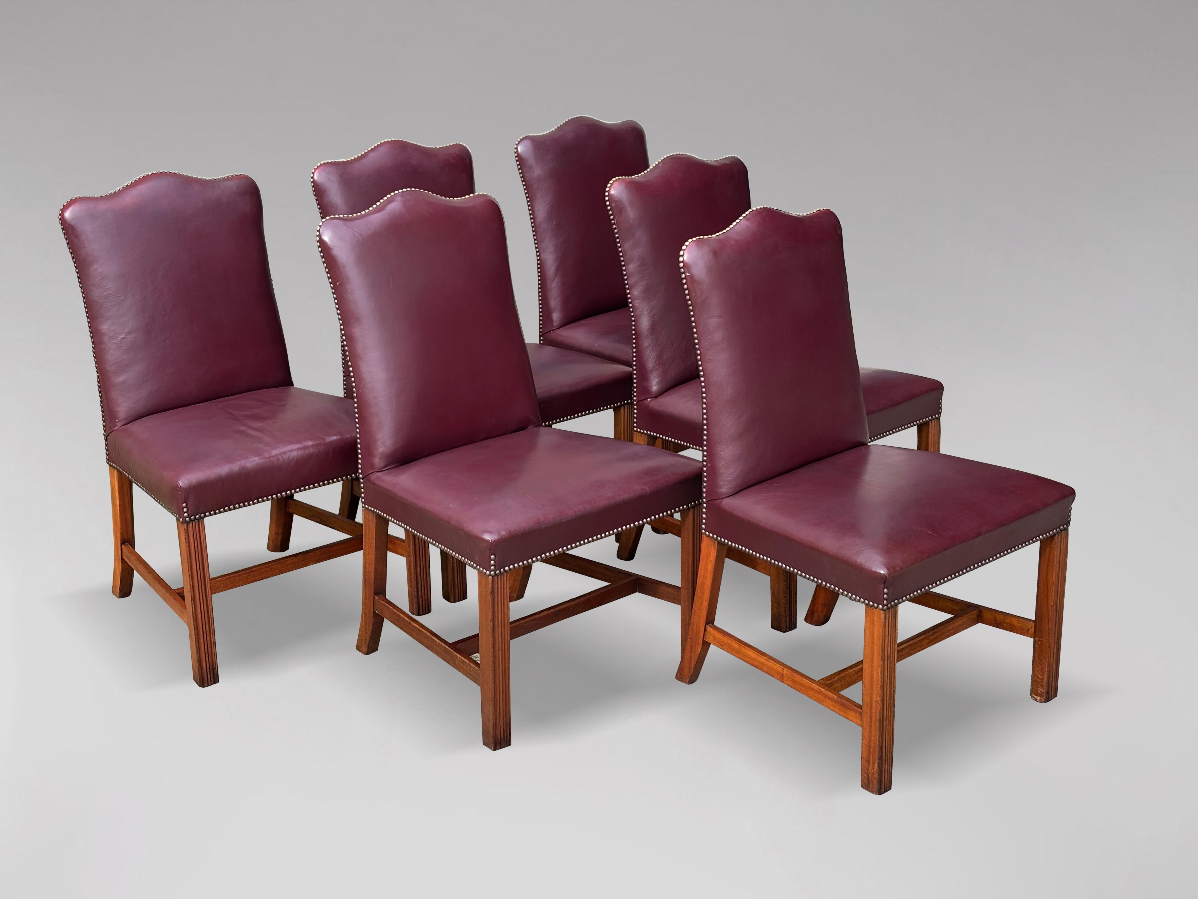 A great quality set of 6, George III style leather upholstered dining chairs. Solid and supremely comfortable high back chairs with arched back, fully upholstered in burgundy colour leather down to a broad seat with brass stud decoration, raised on