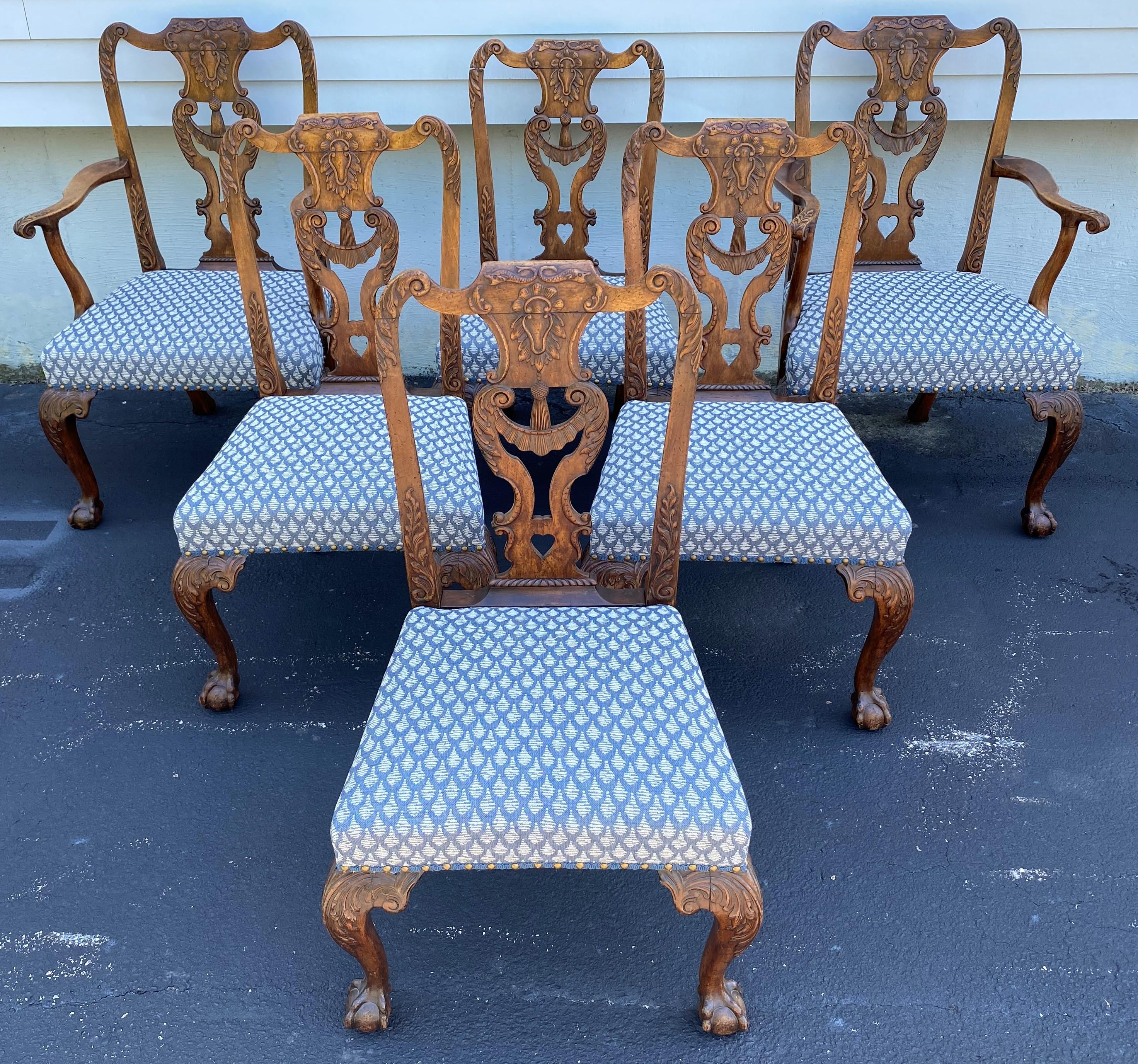 An exceptional set of six Georgian Chippendale dining chairs, including two armchairs and four side chairs, with heavily carved crests with sea serpents or dolphins, splats, and cabriole legs terminating with front ball and claw feet, featuring