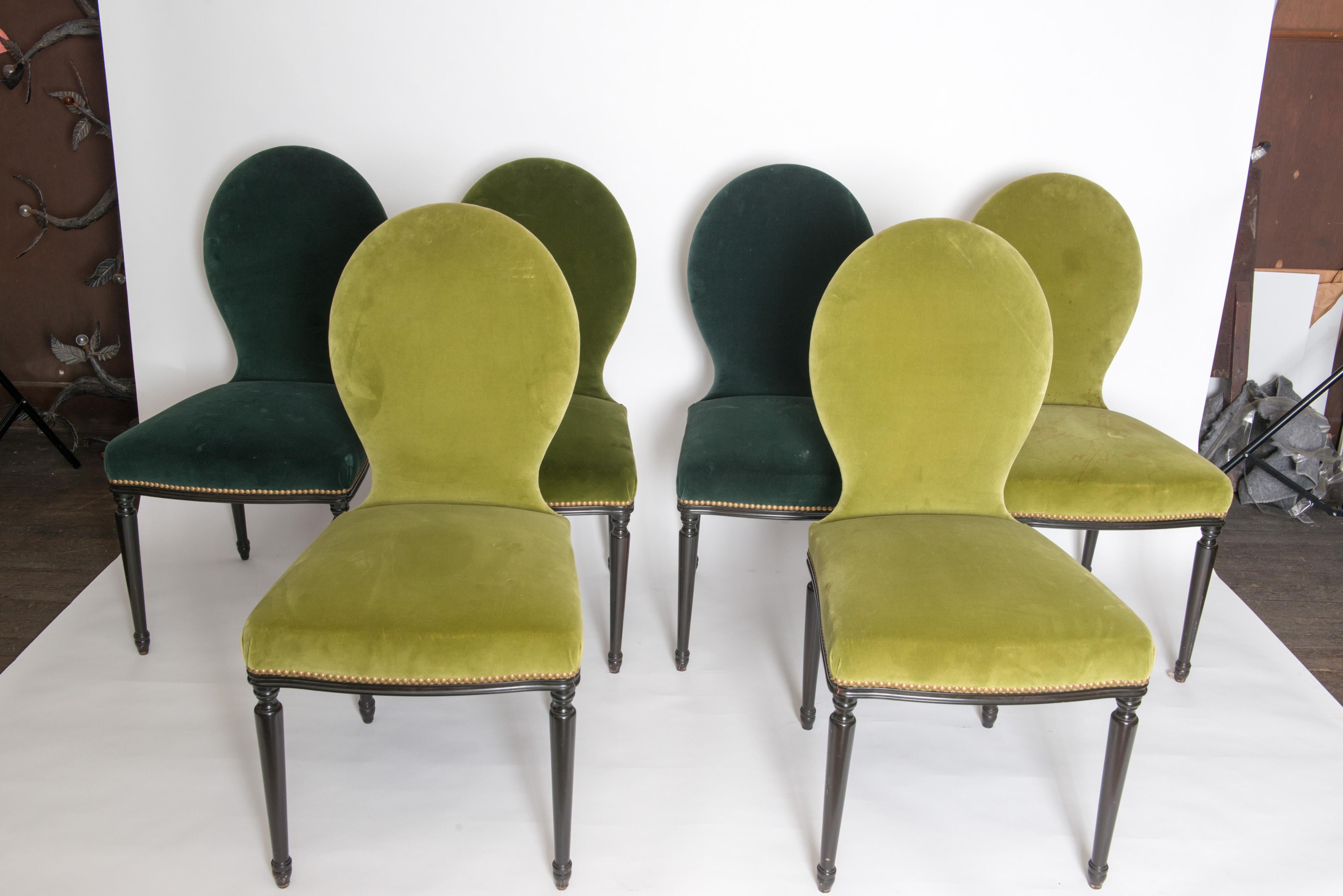 Sturdy set of six Georgian style dining chairs. They are covered in two different shades of green velvet. One chair has a large stain on it. It would be best to reupholster all chairs. The simple streamlined design of these chairs make them