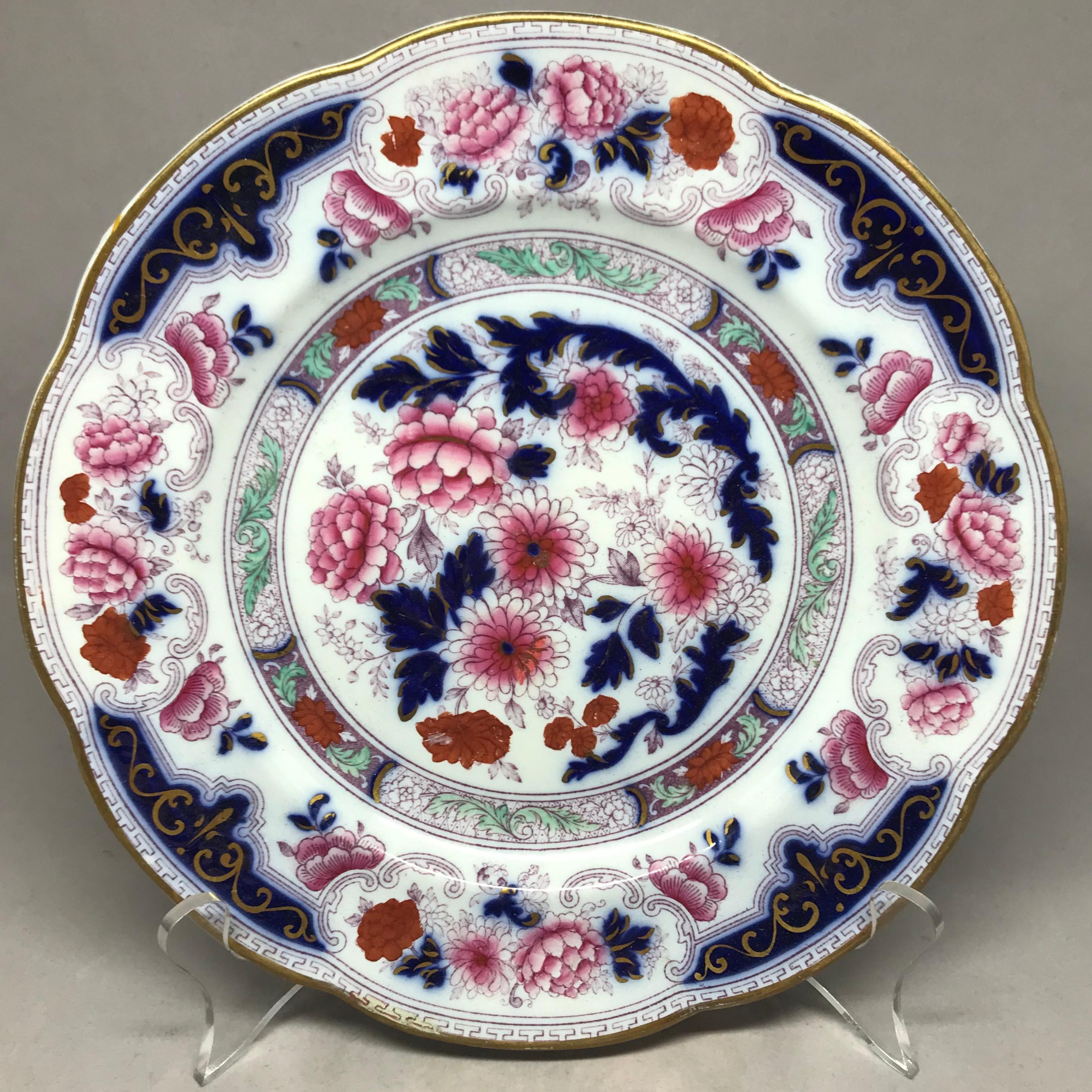 Set of six gilt Imari plates. Six English Imari decorated plates in blue, violet, rose and orange with gilt highlights and lobed rims with gilt Greek key band, with underglaze and impressed markings for Cauldon. England, late 19th