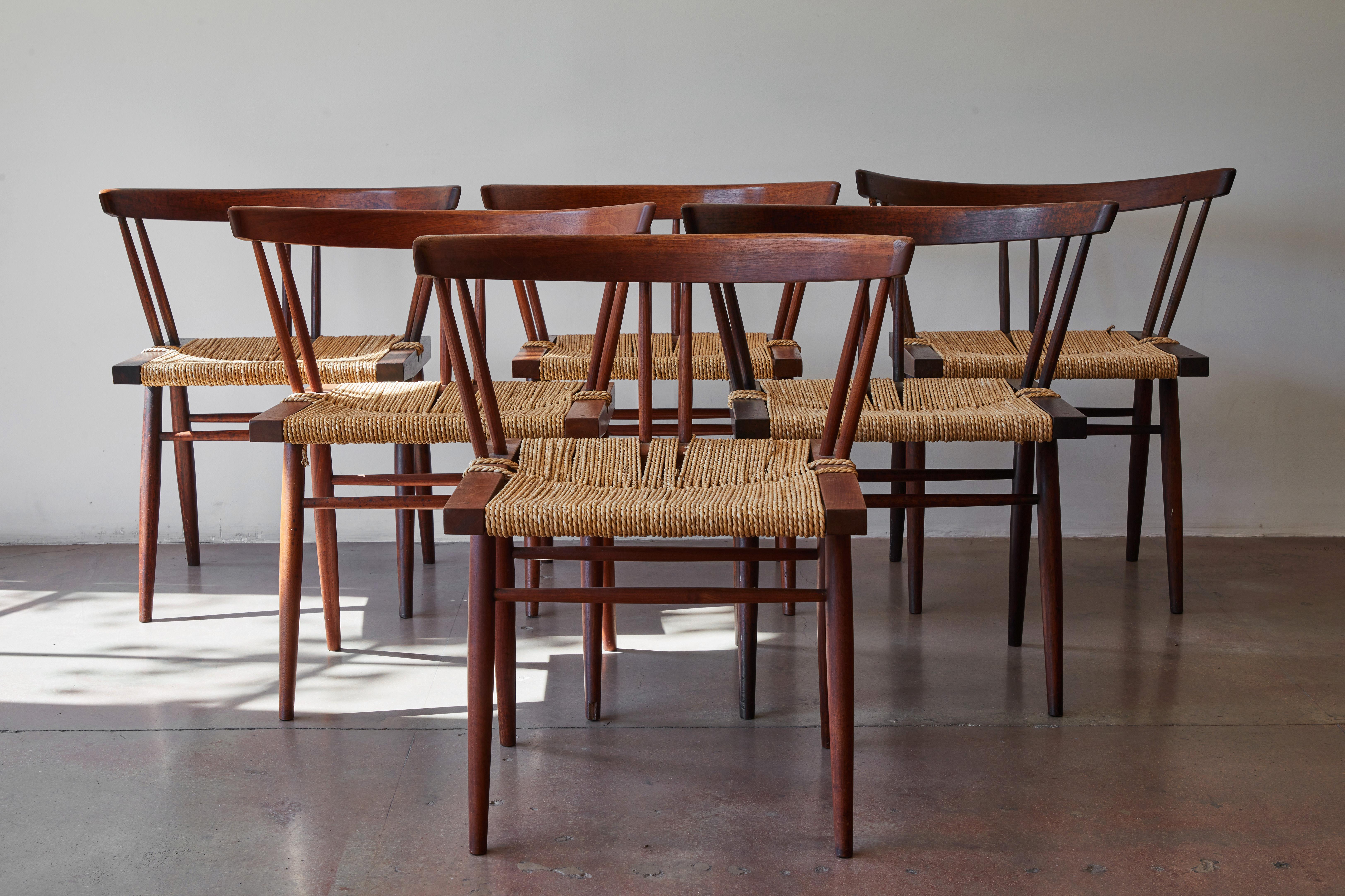 Set of six George Nakashima chairs in cherry and black walnut wood with woven seagrass seats. Made in New Hope, Pennsylvania circa 1950s.