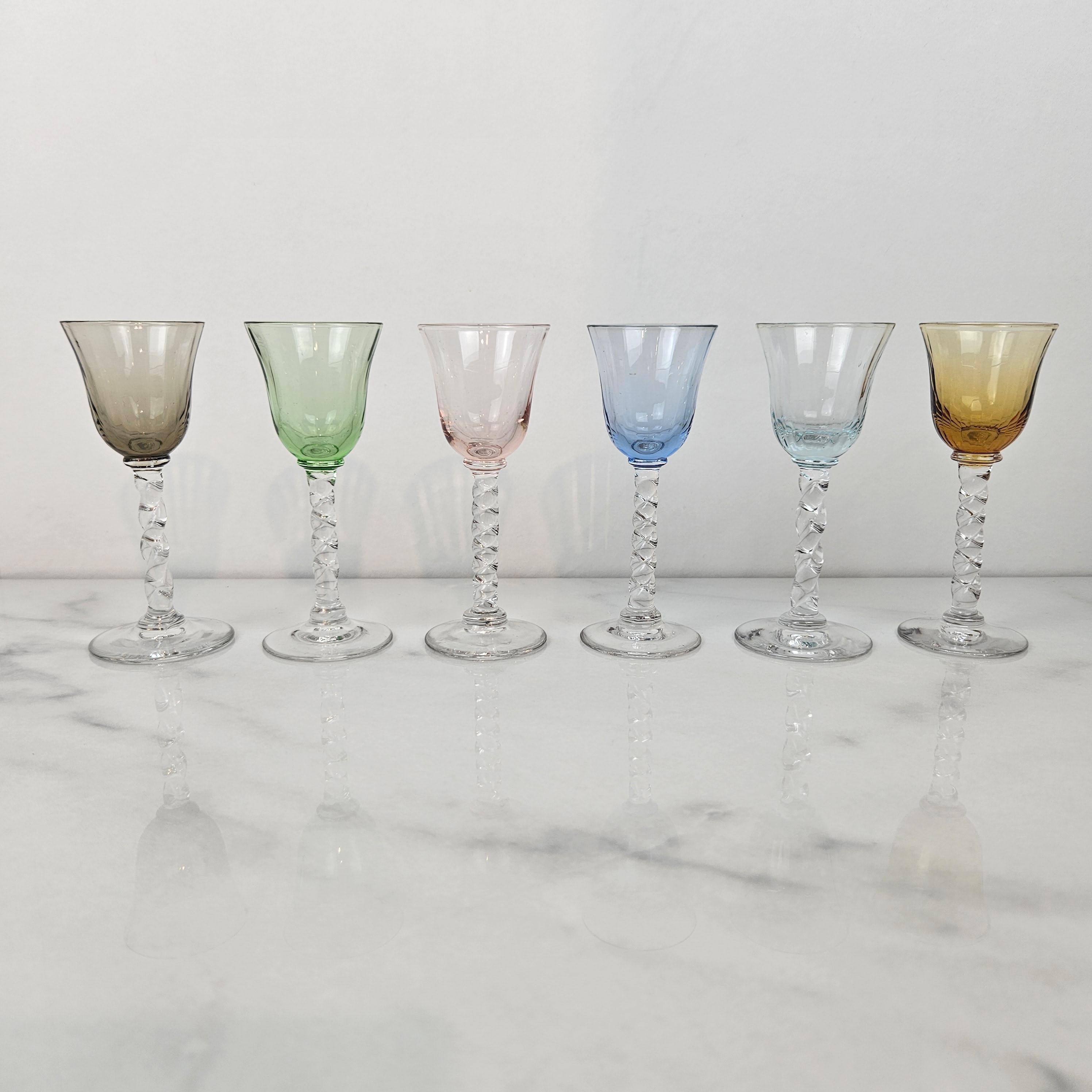 Ein exquisiter Satz von sechs mundgeblasenen Schnapsgläsern aus der Zeit um 1930. Jedes Glas hat einen schön gedrehten Stiel und eine leicht gerippte Schale in sanften, durchscheinenden Tönen - Rauchgrau, Grün, Rosarot, Himmelblau, blasses Aquamarin