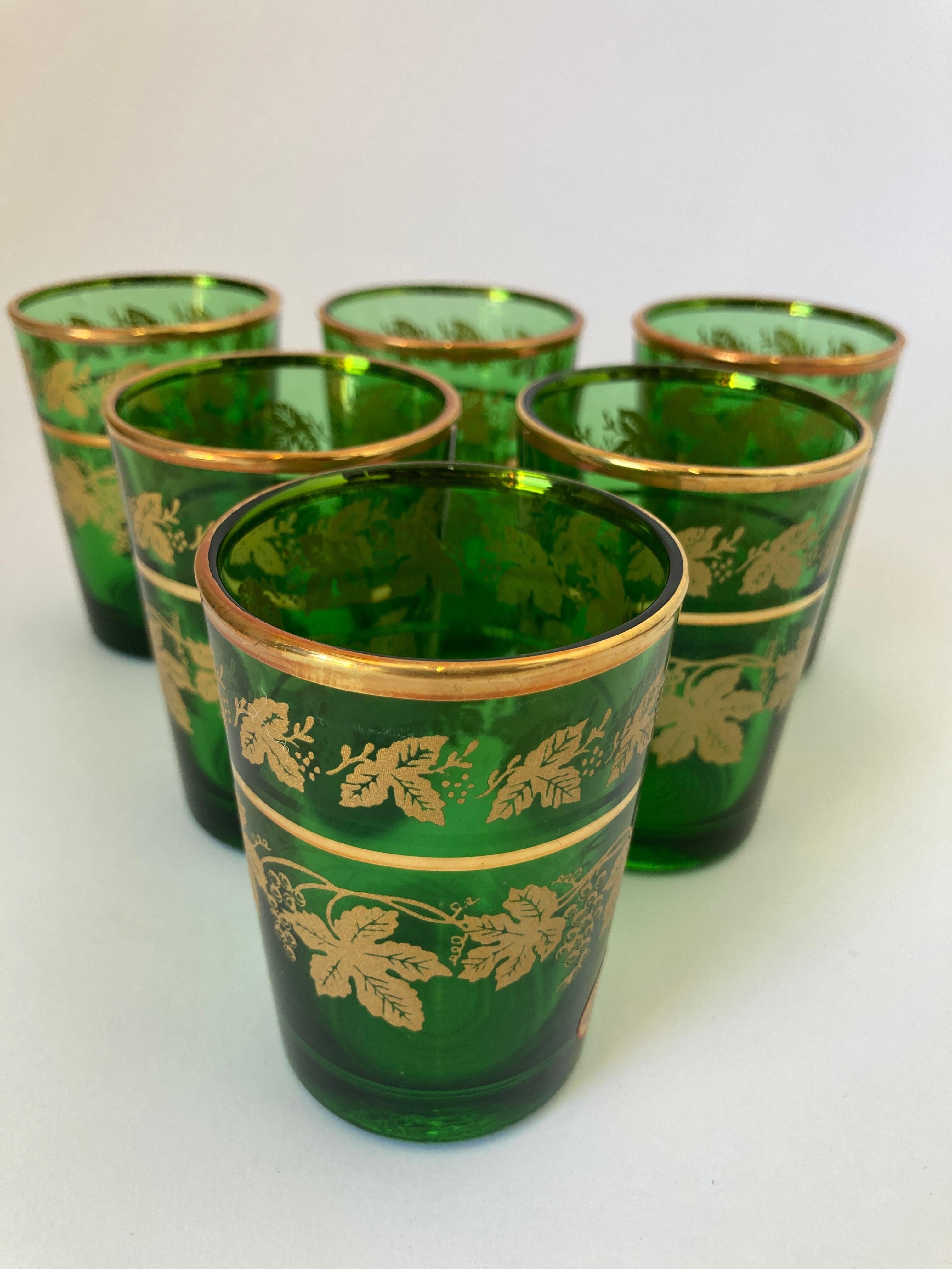 Set of six green and gold handblown Moorish shot glasses.
Use them for Moroccan tea, or any hot or cold drink.
Shot glasses very light finely decorated with a classical gold Moorish pattern frieze. 
Use these elegant glasses for Moroccan tea, or