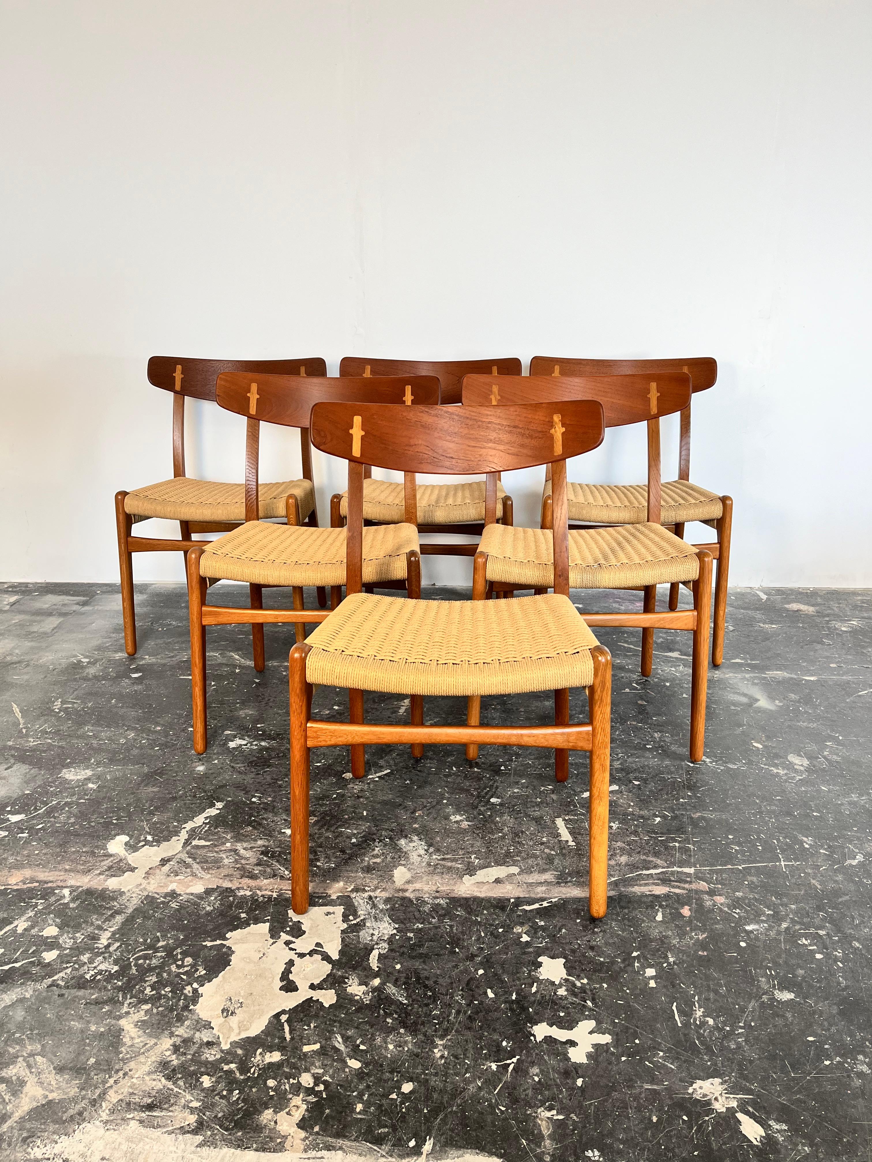 We have a set of 6 CH23 dining chairs designed by iconic furniture designer Hans J. Wegner for Carl Hansen & Søn in Denmark c. 1950’s. The oak and teak wood frames have been restored to excellent vintage condition to showcase the Wegnerian joinery