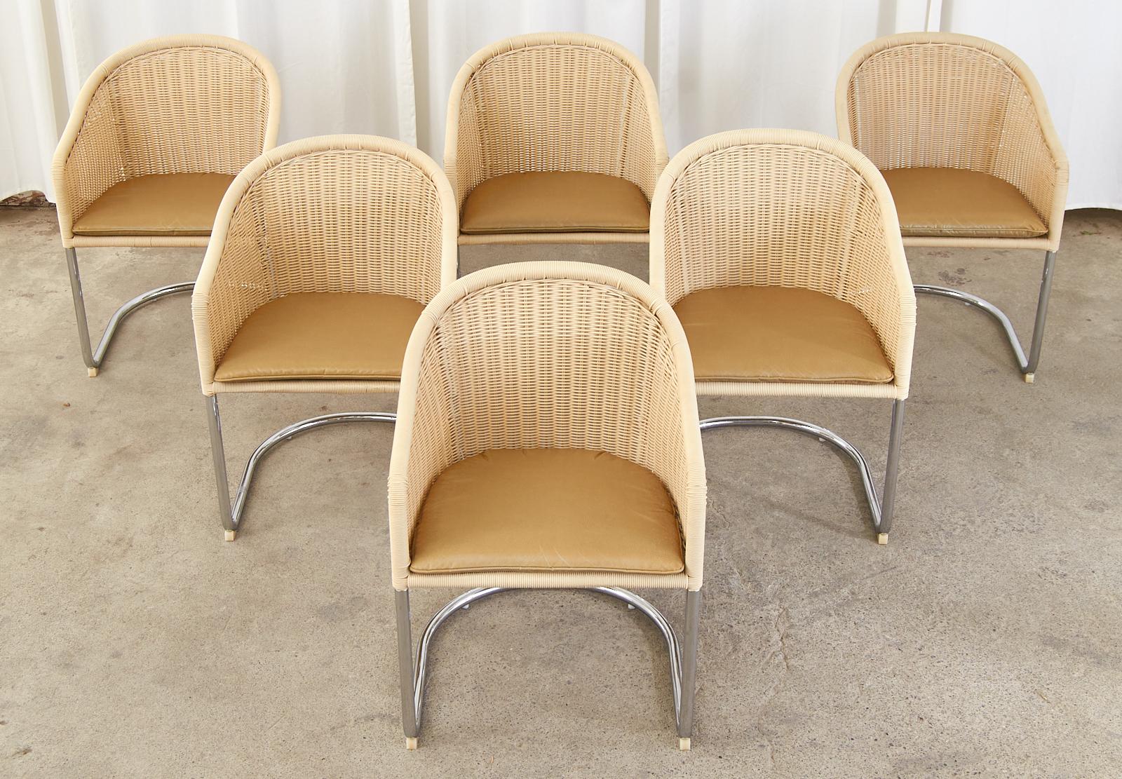 Iconic Mid-Century Modern set of six cantilever dining chairs or lounge chairs. Made in the manner and style of Harvey Probber featuring a chromed steel cantilever frame with a barrel back form. The frame has a faux-wicker resin woven basket style