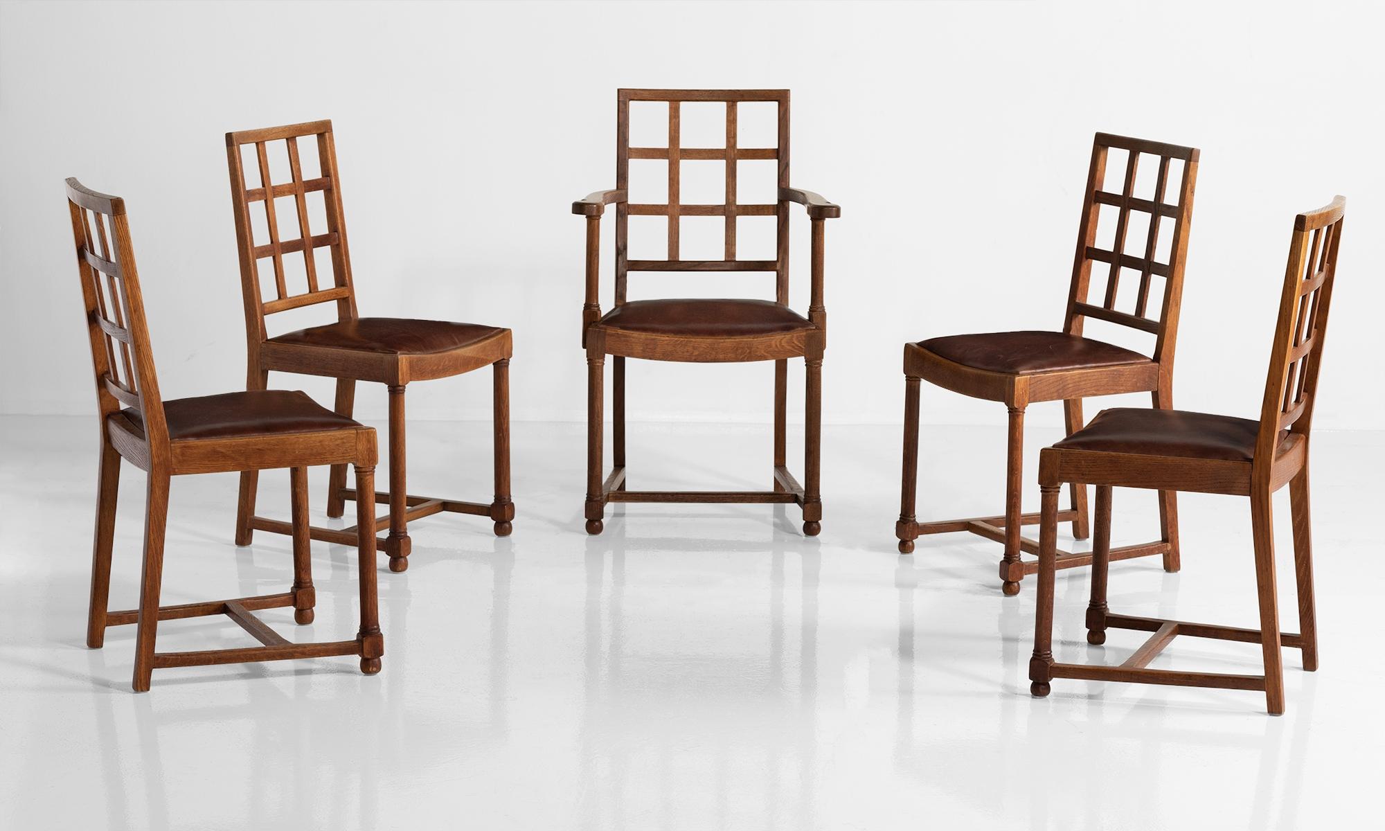 Set of six heals dining chairs, England circa 1930.

Solid oak chairs made by Heals of London, with original leather upholstered seat pads with lattice back.