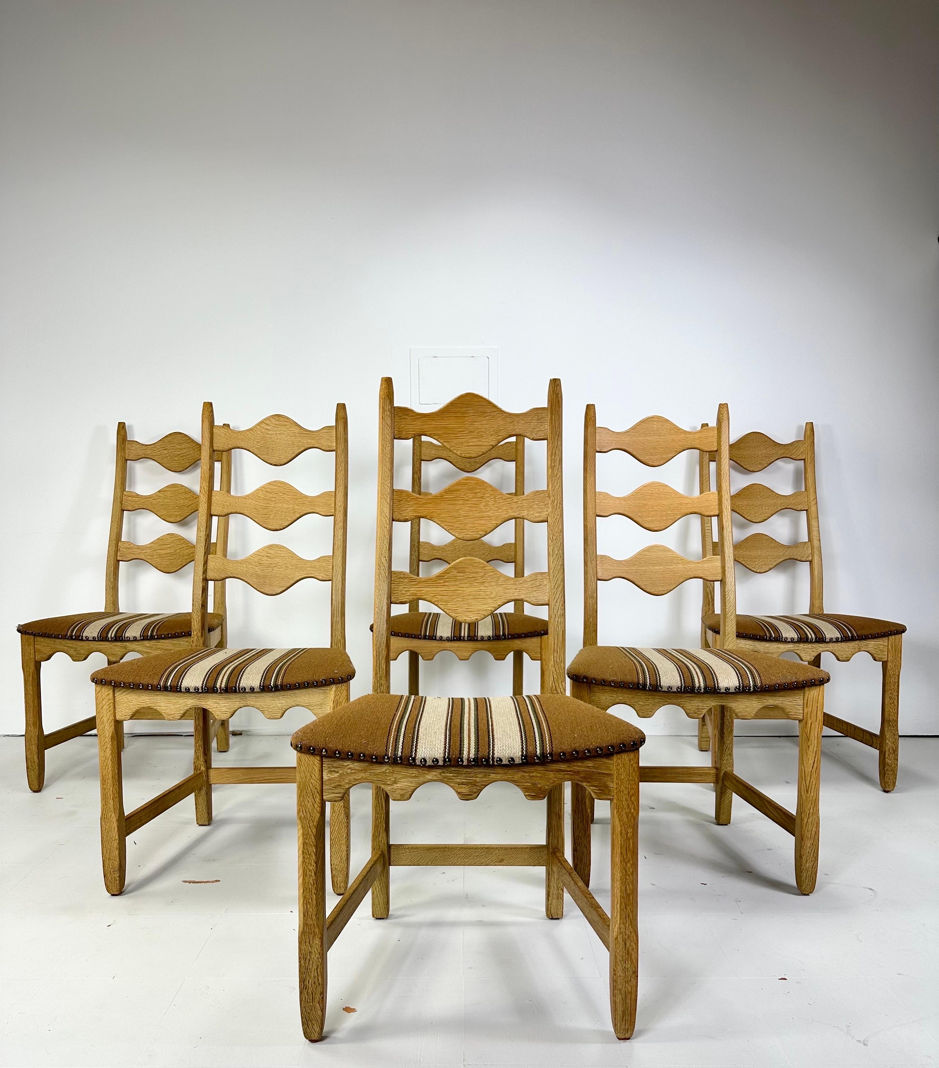 Set of Six dining chairs by Henning Kjaernulf for Nyrup Mobelfabrik. Sculpted Oak frames have a warm rustic and modern feel. Curved backs make these Highback chairs actually comfortable to sit in. Original wool upholstery with nail head details.