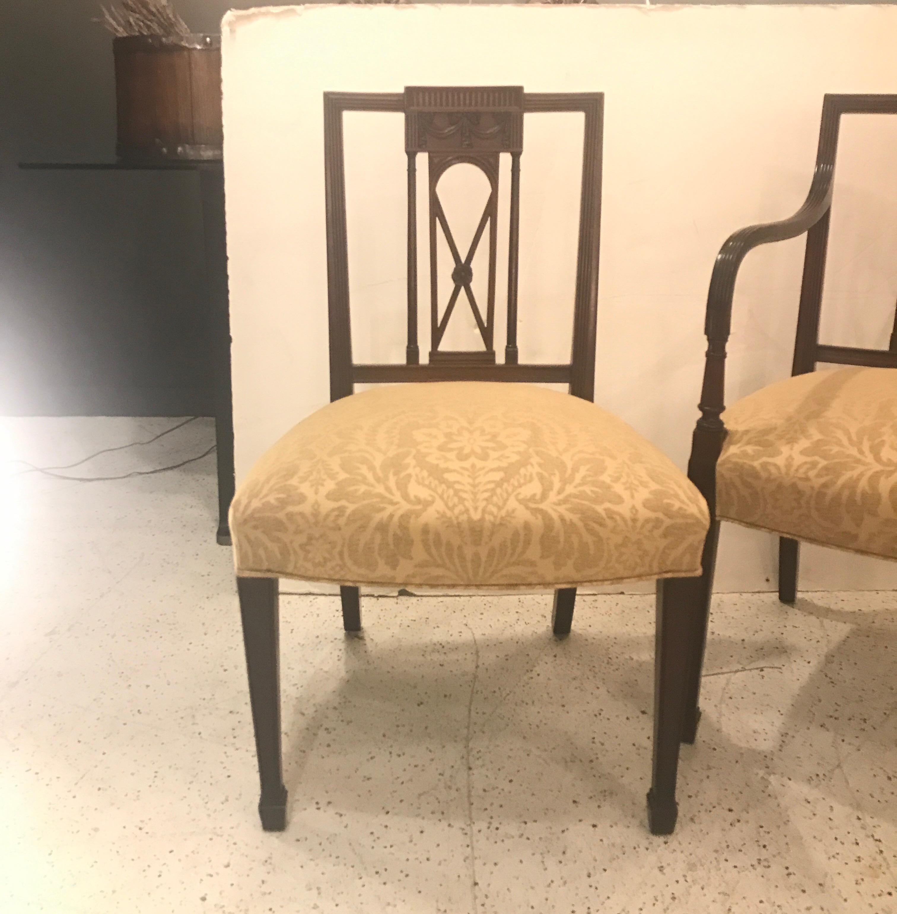 Hand-carved mahogany in a Hepplewhite style in mahogany with new cotton linen damask upholstery. Two armchairs and four side chairs with smaller square backs and hand-carved details. The arm chairs with reeded simple arms. The square legs with