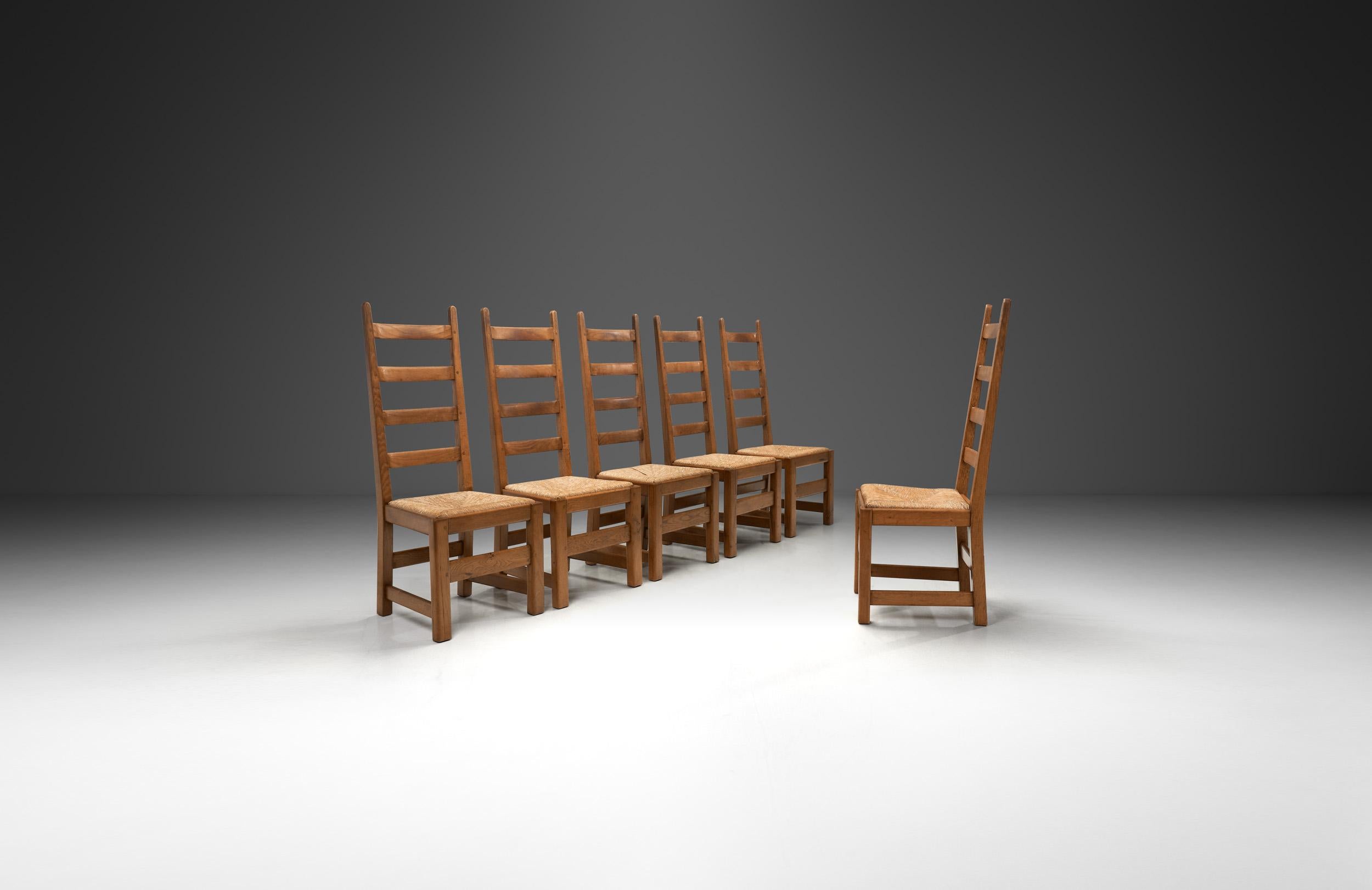 Queste sei sedie da pranzo con schienale alto sono un eccezionale esempio di artigianato francese della metà del XX secolo. Unendo la semplicità rustica all'eleganza funzionale, riflettono il movimento del dopoguerra verso materiali onesti e