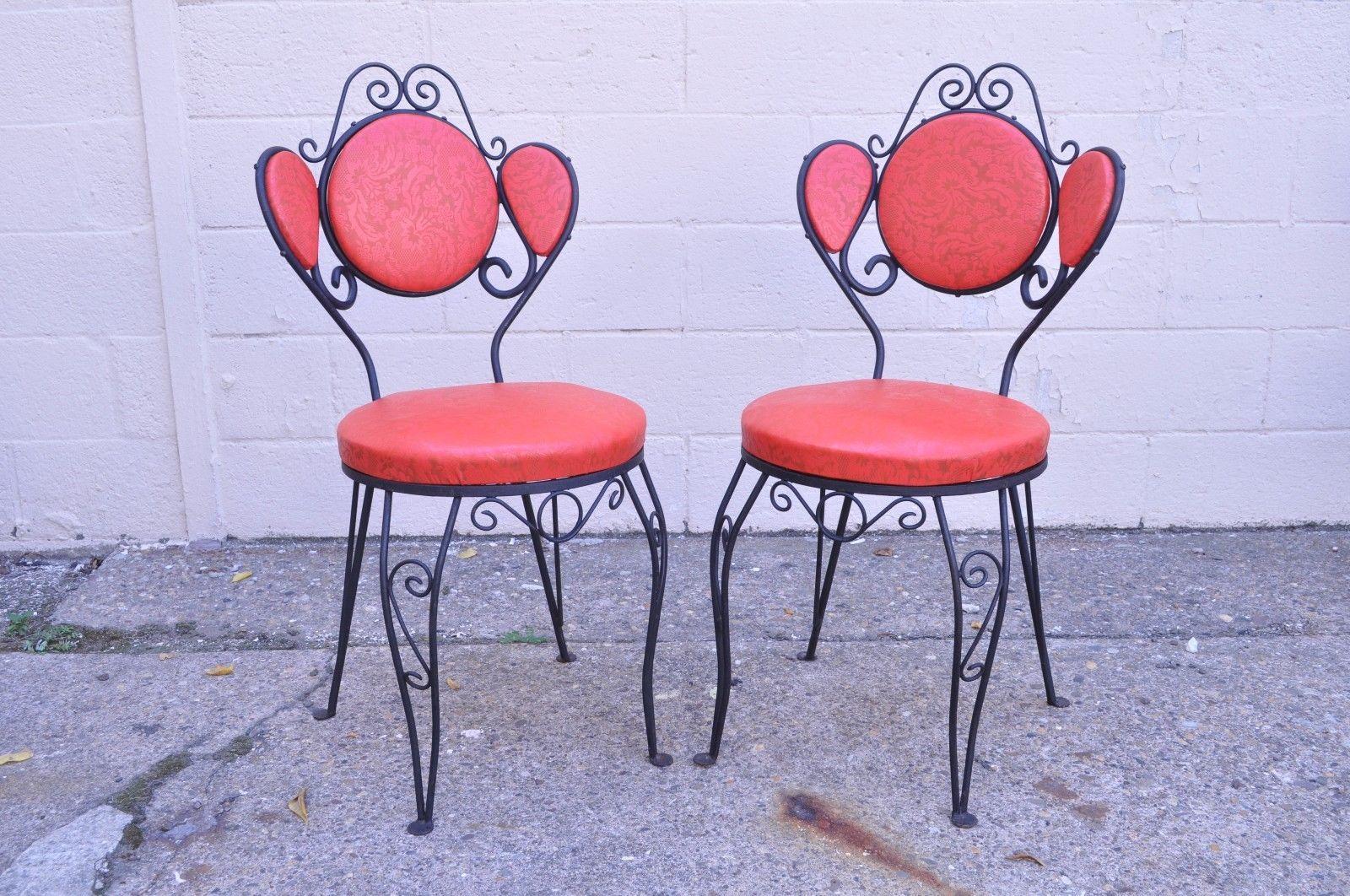 Set of six vintage Hollywood Regency wrought iron ice cream parlor dining chairs. Item features six side chairs, triple backs, scrolling wrought iron frames, red floral embossed vinyl upholstery, nailhead trim on backs, circa 1950s, American.