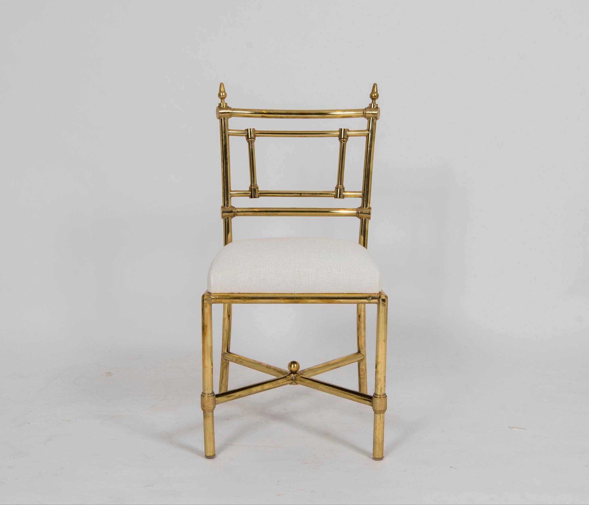 A vintage set of heavy brass Italian dining chairs with newly rebuilt and upholstered seats in a white linen.