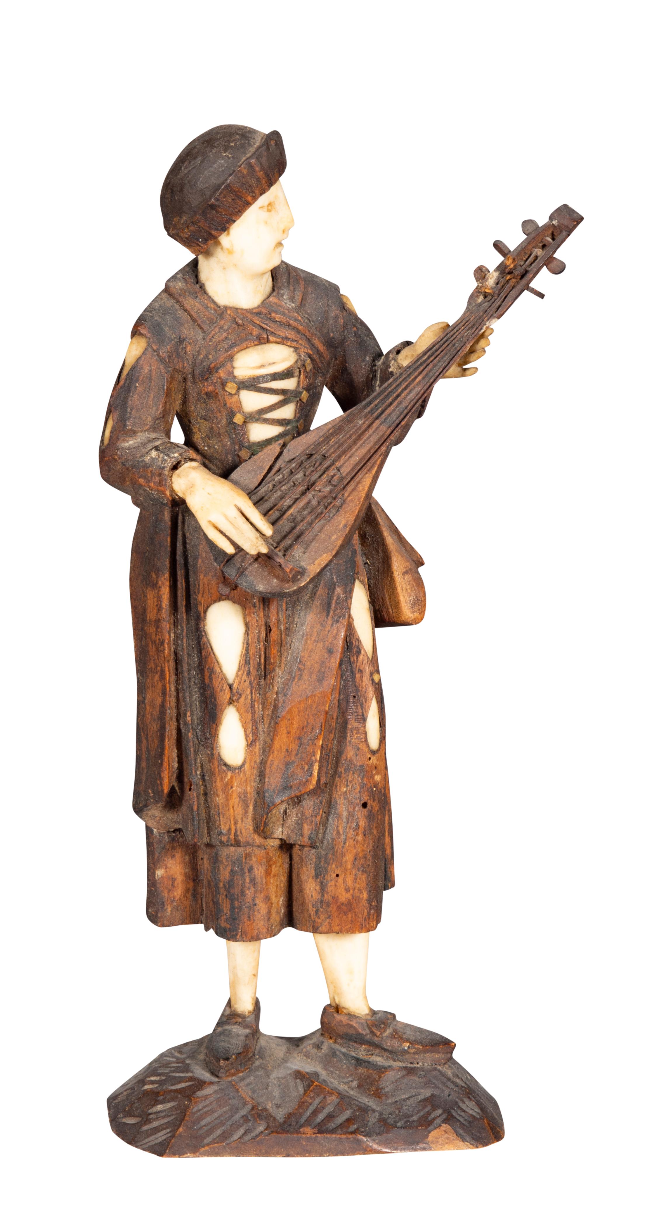 Six carved figures playing instruments in peasant dress. 