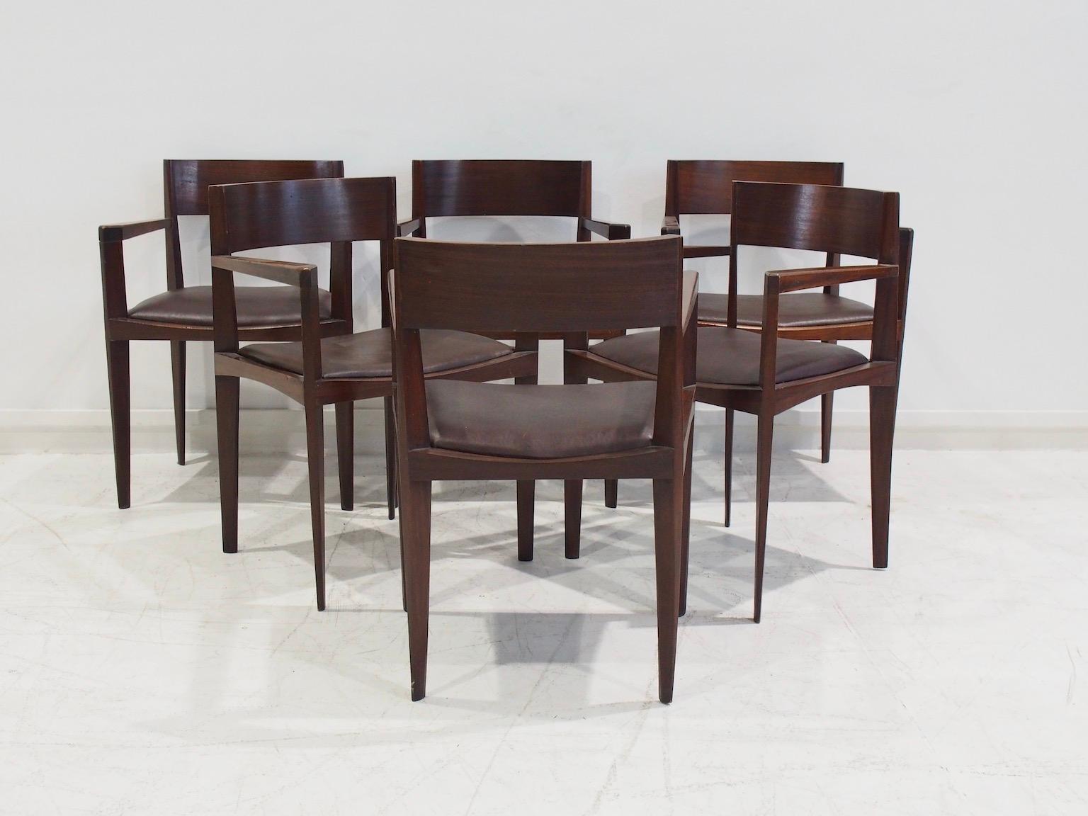 Set of six Italian modern dining chairs. Sleek design with elegantly shaped narrow legs. Solid dark stained wood and chocolate brown faux leather seat covers. 