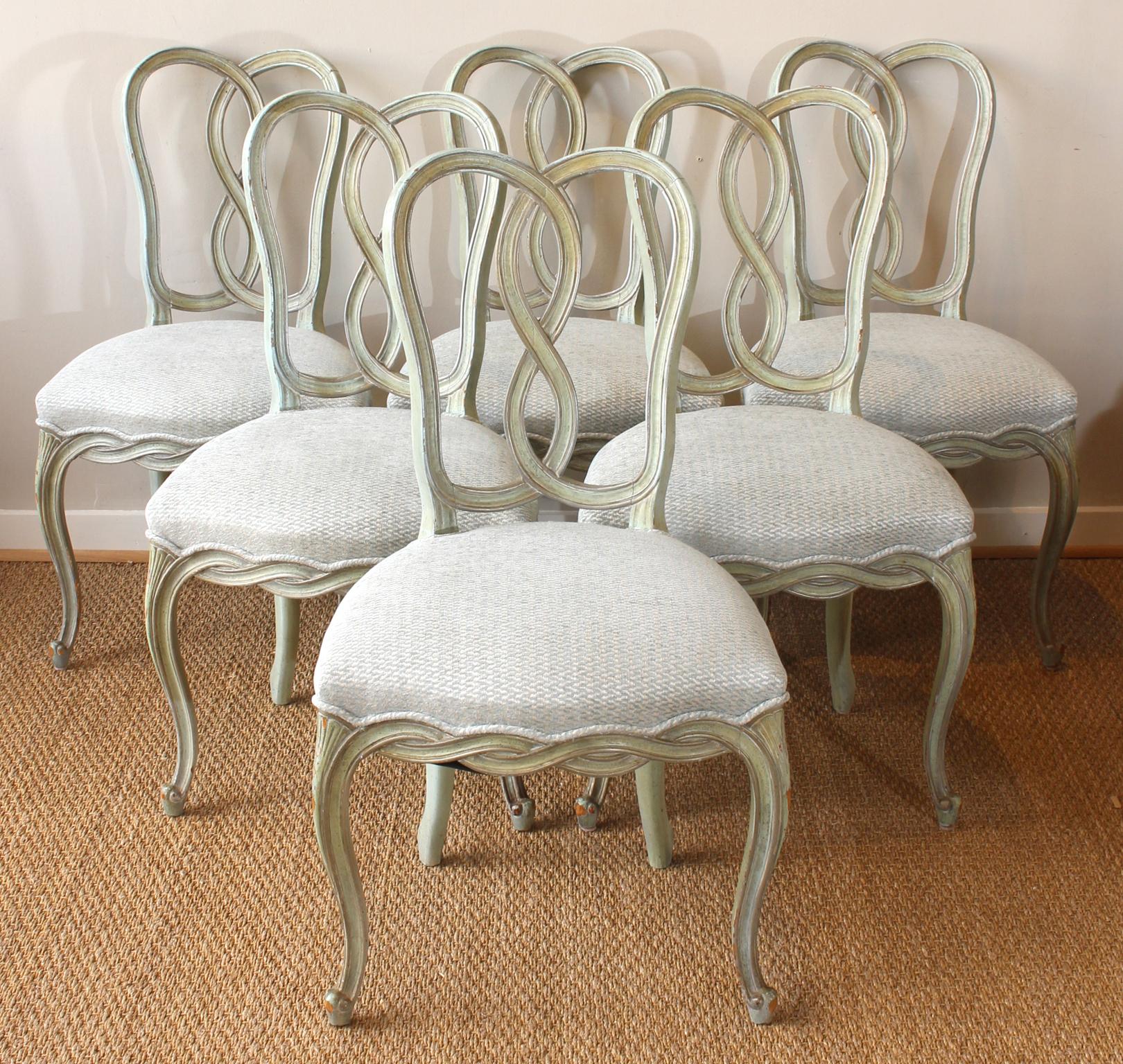 A lovely set of six mid-20th century Italian carved and painted dining chairs comprising six sides recently upholstered in a soft blue/green linen chenille fabric.
