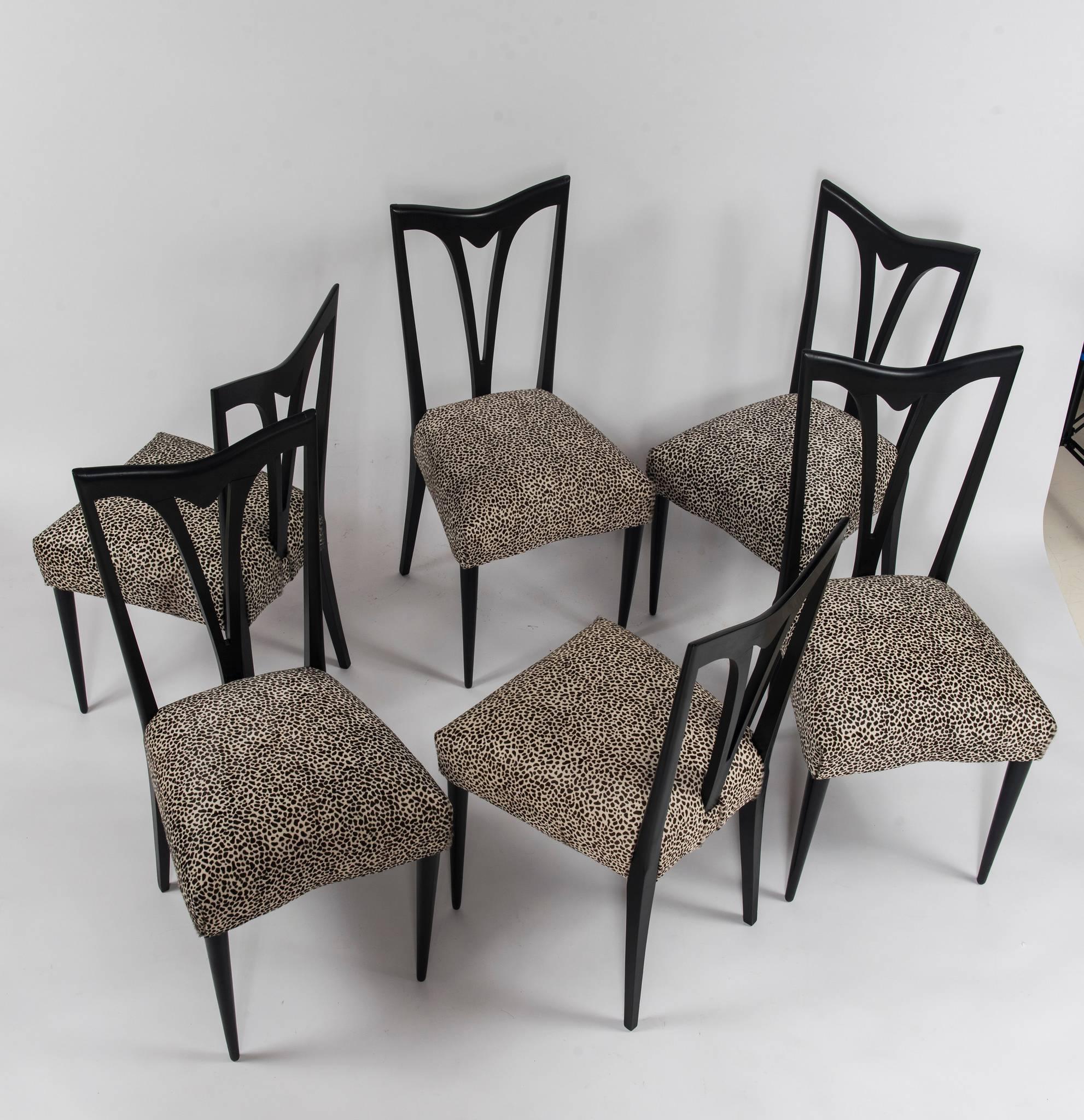 A set of six midcentury Italian dining chairs newly upholstered in a black and white leopard printed hair hide.