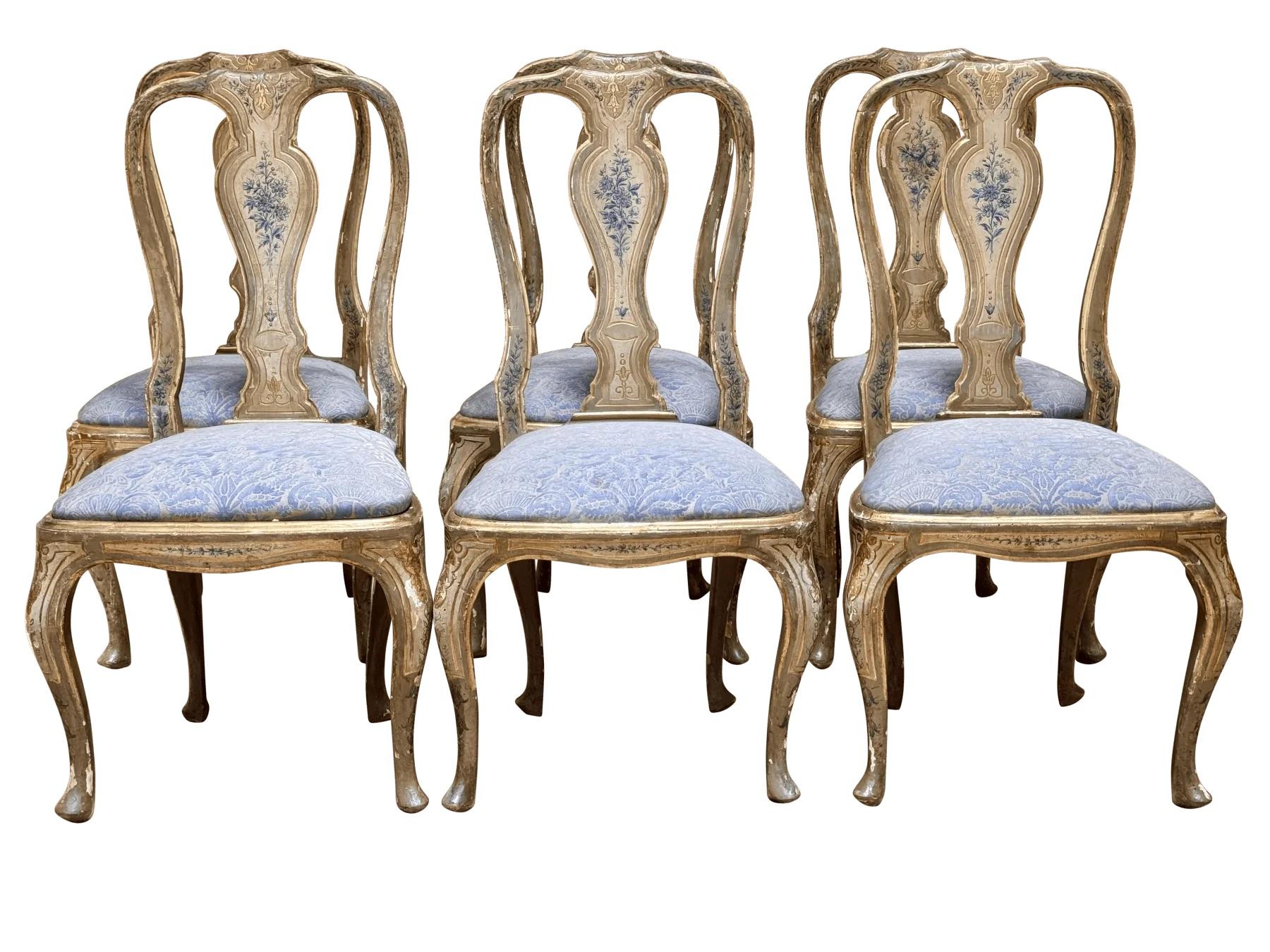 A Set of Six  period Italian Rococo Polychrome and Parcel-Gilt Dining Chairs-18th Century.  Possibly Florence or Venice.  Each yoke-form crest rail over baluster splat painted with floral bouquets, slip seats upholstered in Fortuny fabric.  Height