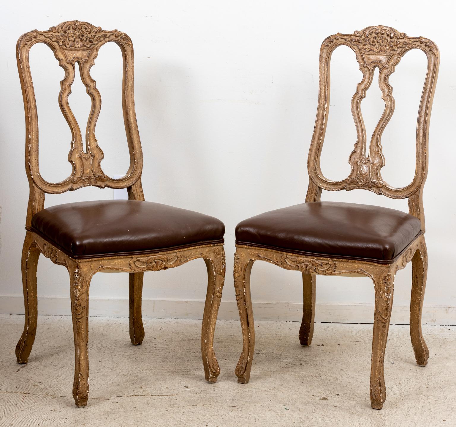 Set of six carved Italian Provincial style side chairs with leather upholstered seats on cabriole legs. The chairs feature a pierced back splat and a carved top rail with floral motifs. Further detail includes scrolled foliage accented on the bottom