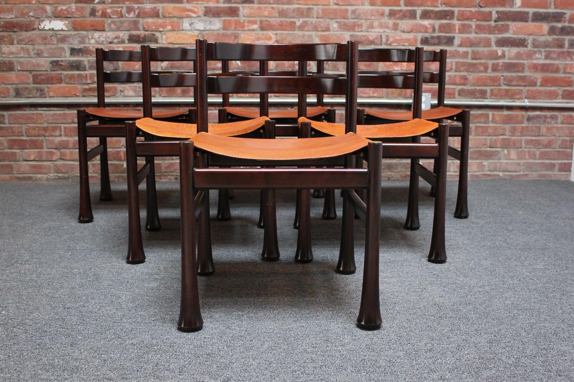 Impressionnant ensemble de six chaises de salle à manger en bois de rose avec sièges en cuir et accents en laiton par Luciano Frigerio (ca. 1970, Italie).
Des cadres profondément sculptés avec un design de dossier à lattes incurvé et des pieds épais