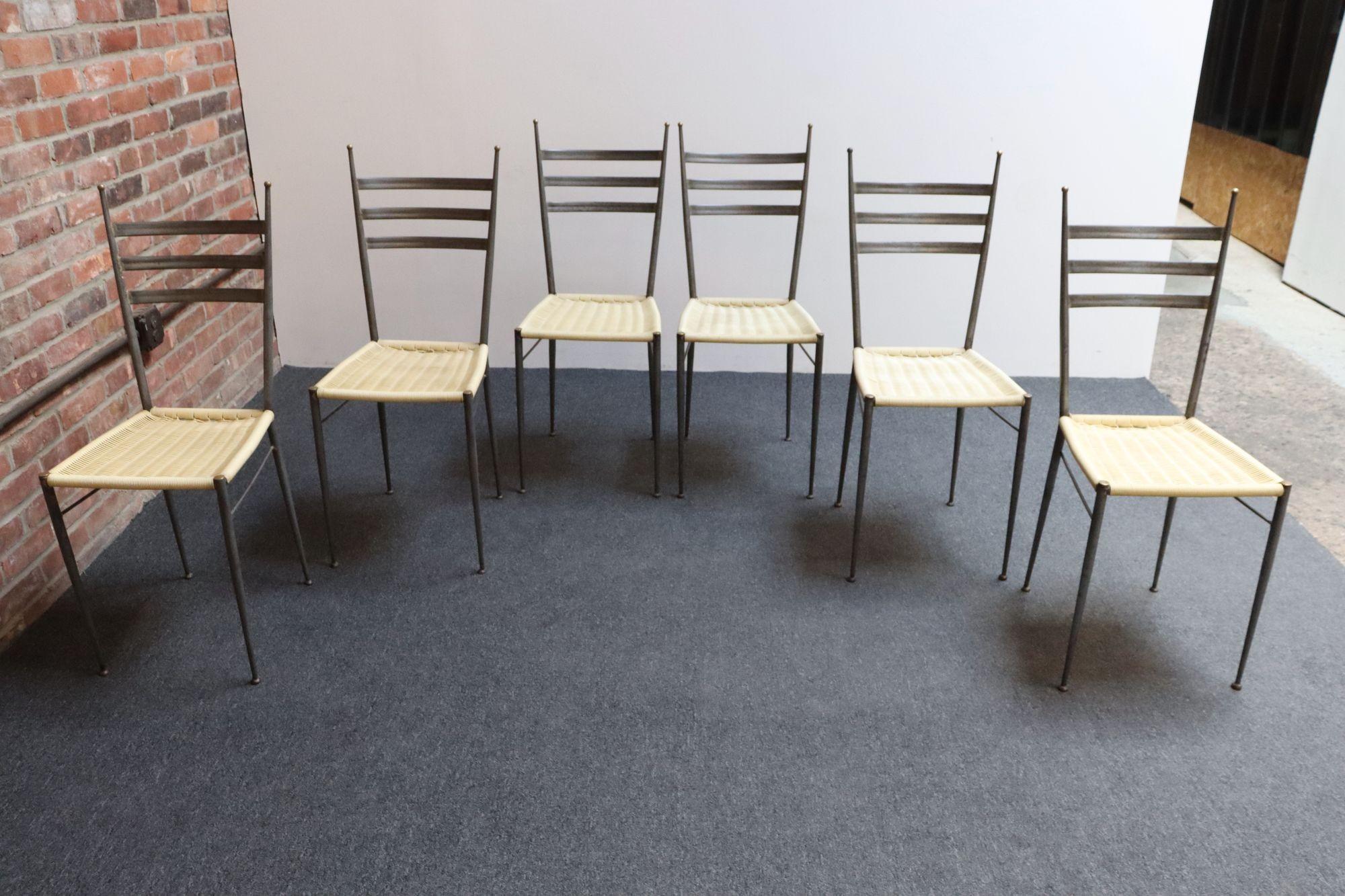 Ensemble de six chaises de salle à manger italiennes en acier avec fleurons/accents en laiton et sièges en plastique beige tissé à la main (vers les années 1950, Italie).
Une version plus originale de la chaise 