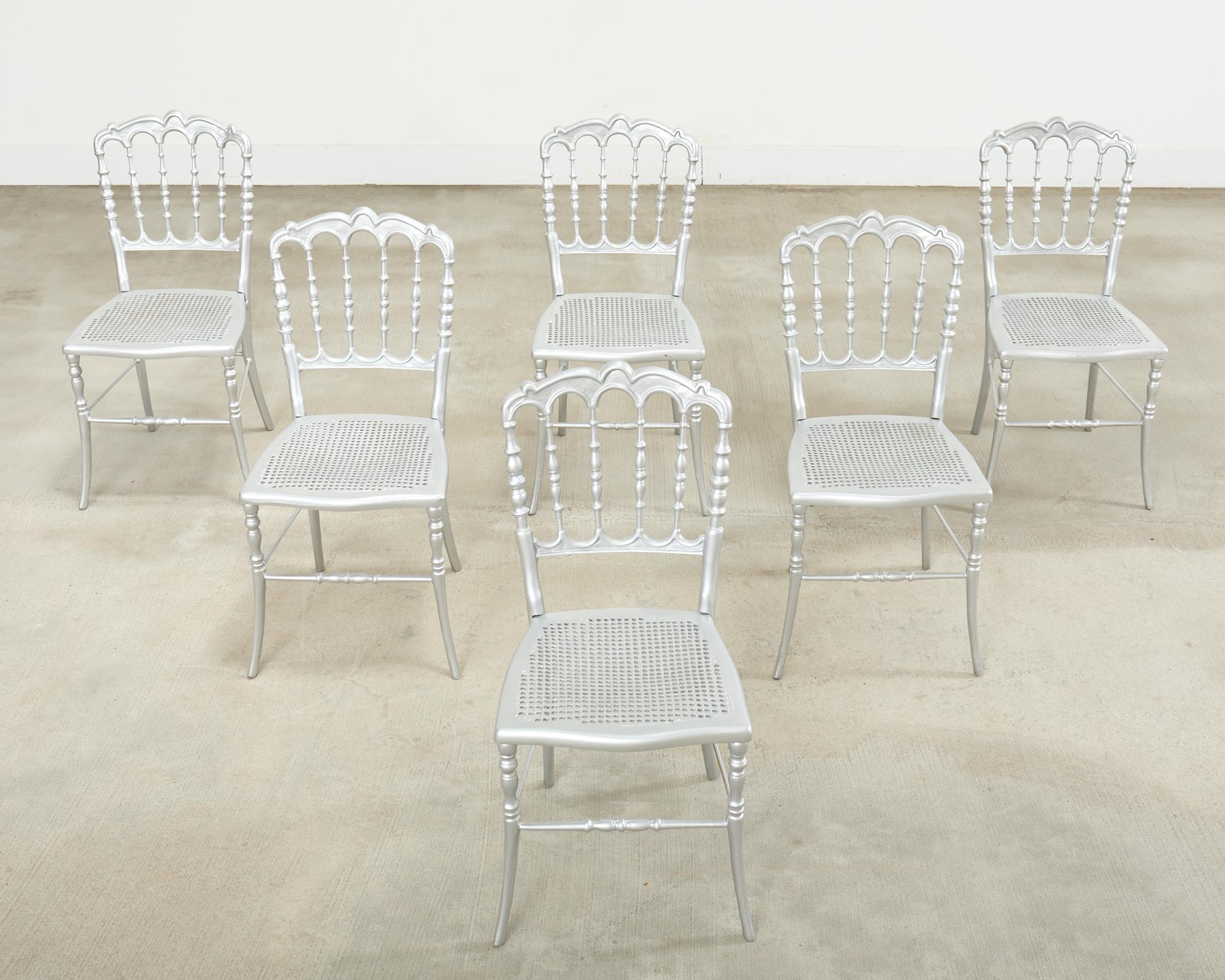 Raro set di sei sedie da pranzo o da matrimonio di Chiavari in ferro con finitura verniciata in argento metallizzato. Le sedie sono molto pesanti e solide, con schienale tornito e seduta in finta canna intrecciata. Venduto come set da sei. Da una