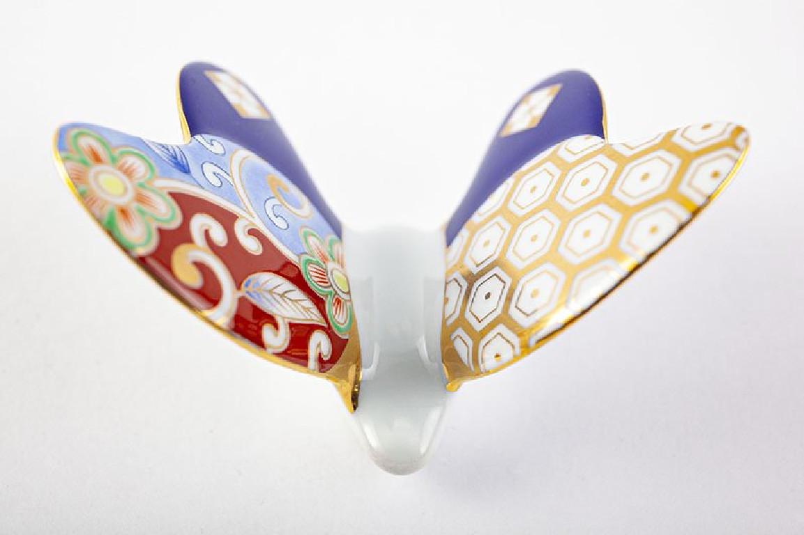 Set of six Japanese contemporary porcelain chopstick rests, hand-painted in beautiful Japanese brocade patterns in cobalt blue, red and gold, on an elegant butterfly shaped body. It comes in a beautiful custom-made gift box. Dimensions: W 3 in, D 2