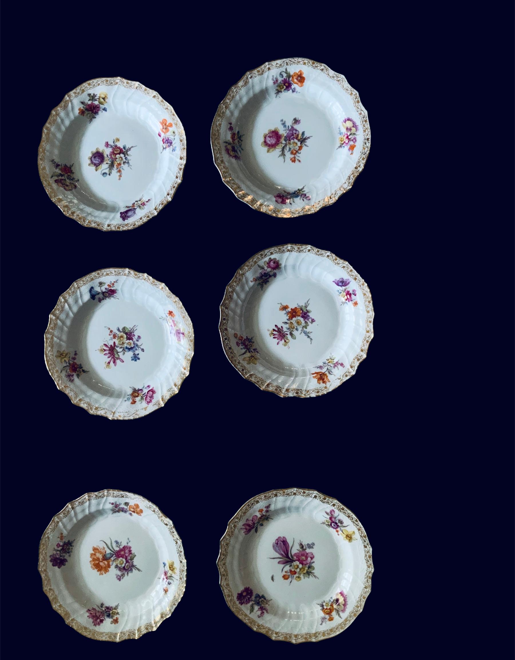 This is a set of six KPM bread and butter plates. They depicts a bouquet of flowers in the center and four different small bouquets around the border. There is also some gilt vine of hearts and Ivy leaves adorning the border in addition of the