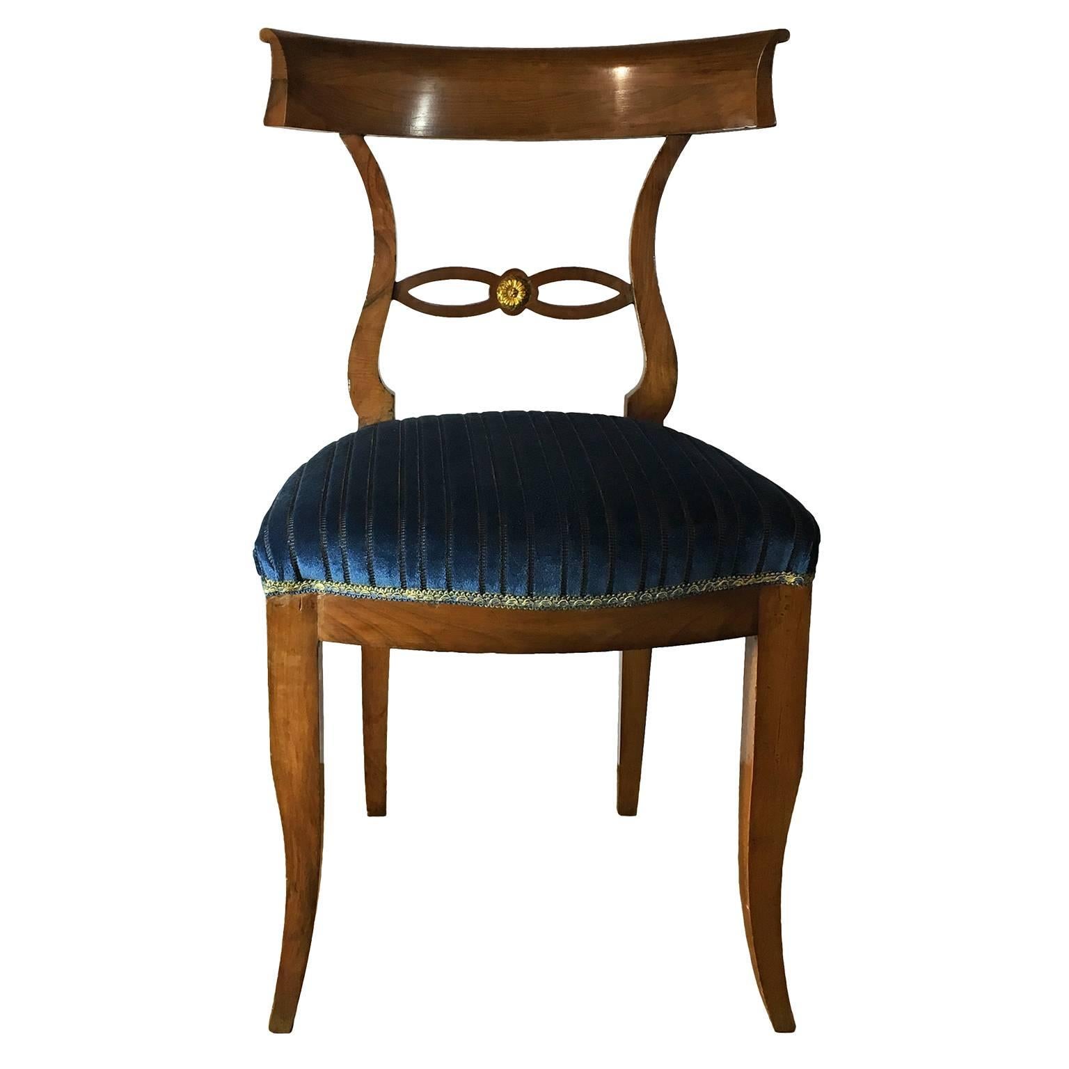 An elegant set of six Italian directory style chairs in solid walnut wood. The chairs present a beautiful Silhouette with elegant lines, a loop with ormolu detail underneath the curved back and slightly curved legs. Newly reupholstered in a striped