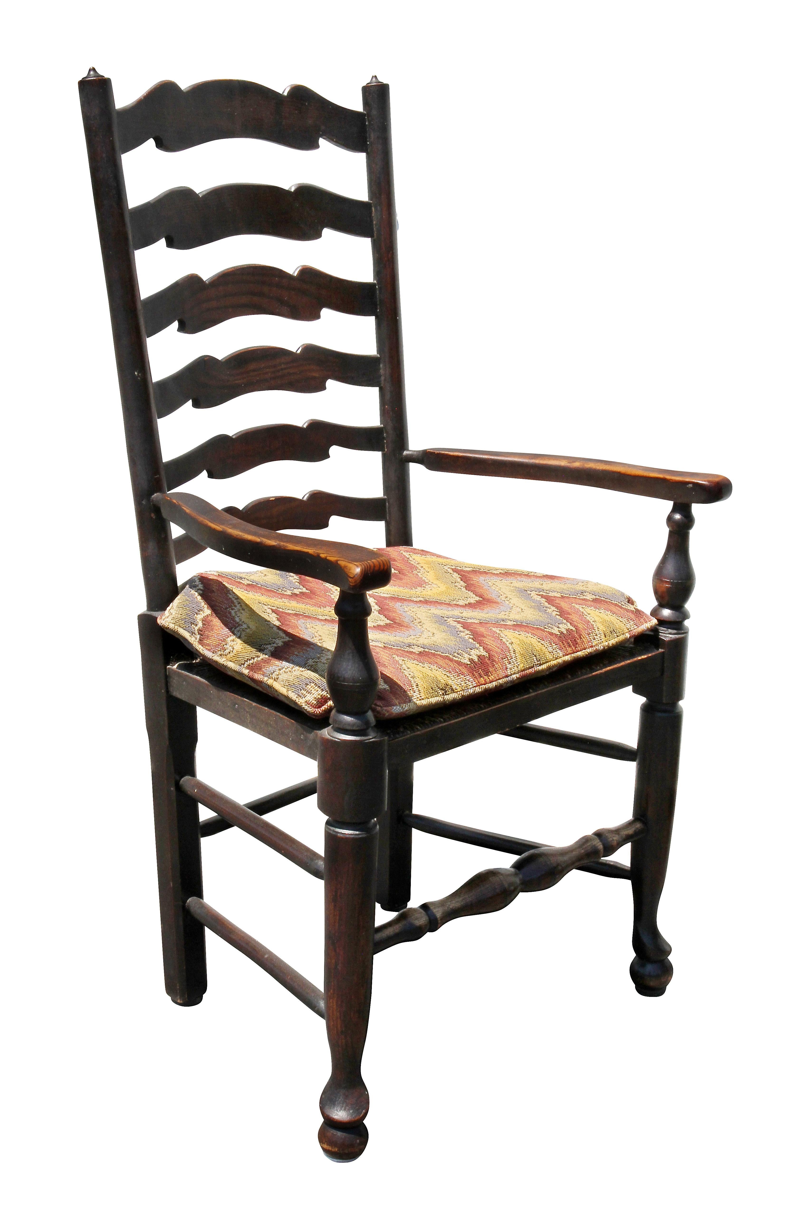 Comprised of a pair of armchairs and four side chairs, ladder back with rush seats, turned circular legs and pad feet, and turned stretchers.
