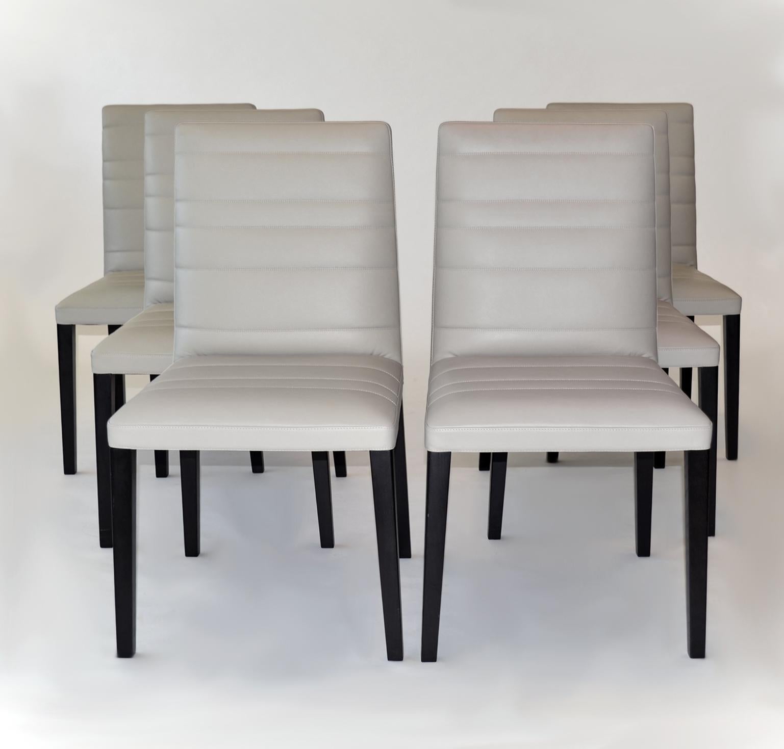 Set of Six Leather and Wood Dining Chairs by Poltrona Frau, 'Louise' 

Color is an light gray to putty. The structure is crafted with solid ash and beech wood with polyurethane foam padding. The springs are made with elastic belts. The legs are