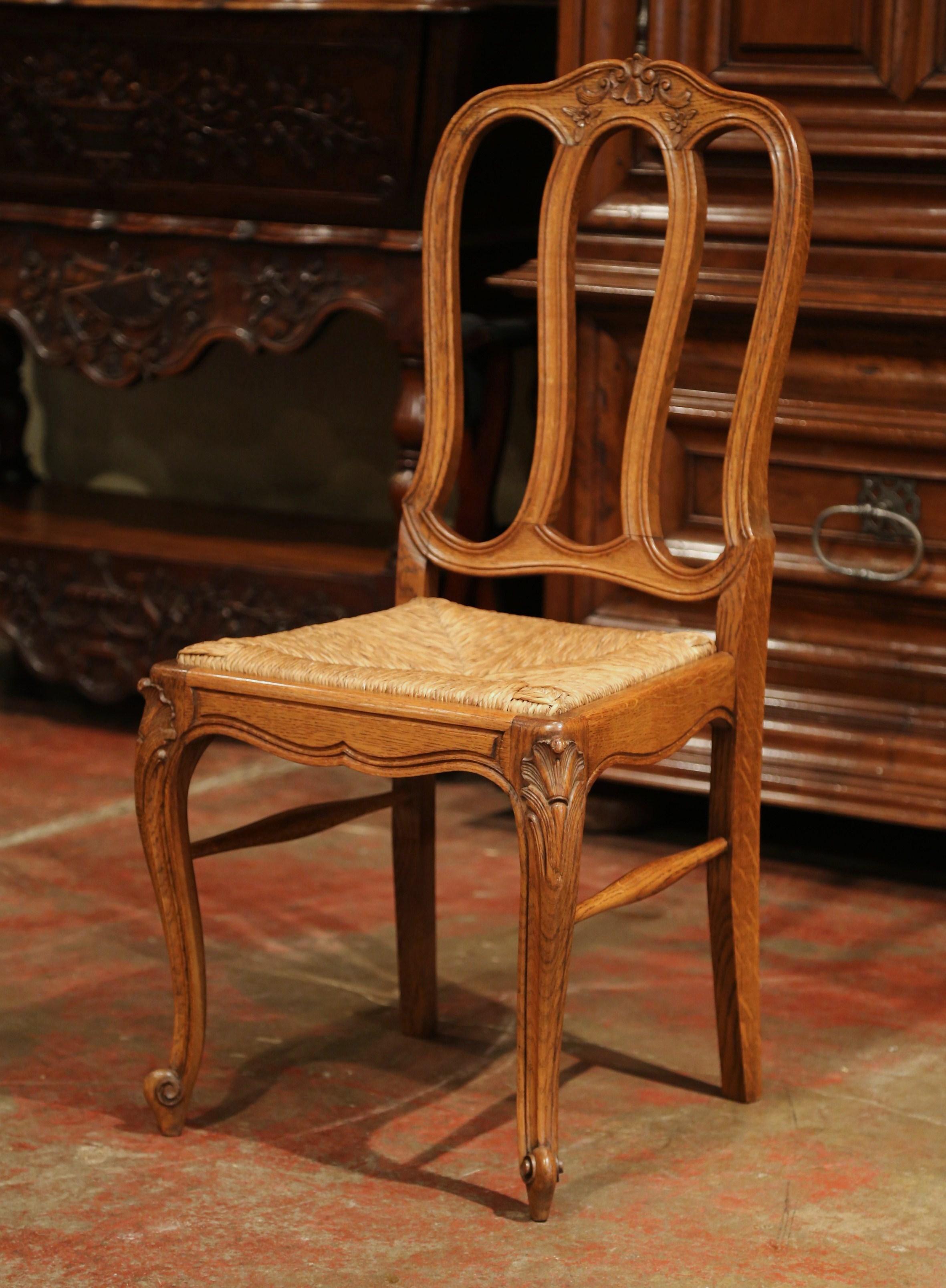 This elegant set of six country chairs was crafted in France, circa 2000. Each chair is made of solid oak and has a tall arched back with four vertical ladders. The chairs are embellished at the pediment with traditional French floral and shell