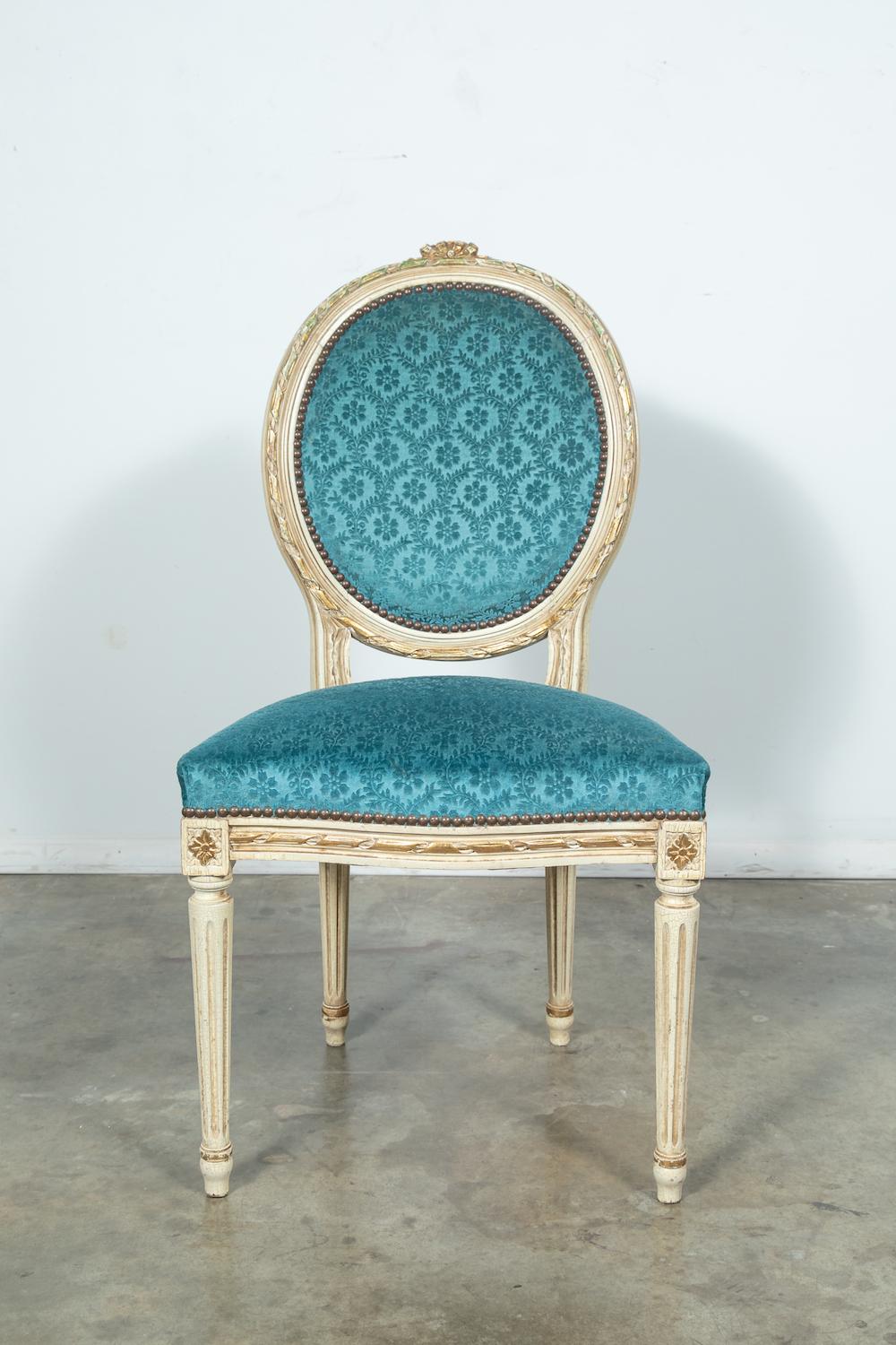 A wonderful set of six French Louis XVI style Maison Jansen attributed dining chairs in a fine parcel-gilt and paint decorated finish with touches of emerald green paint and a crackle finish having medallion shaped backrests with an intricately