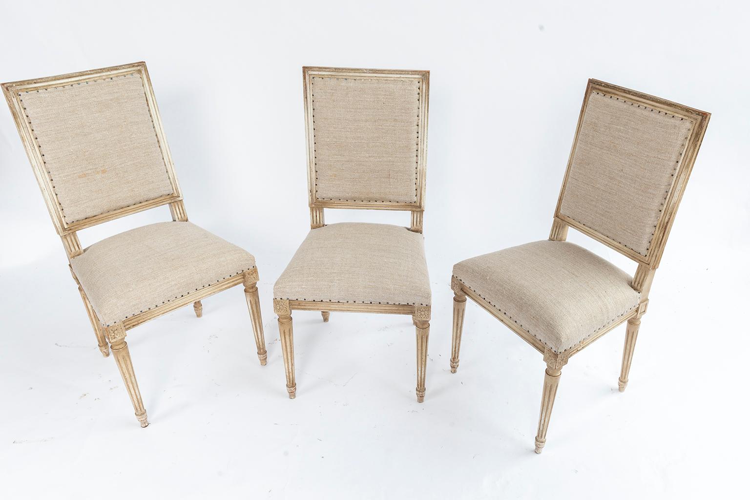 Set of six Louis XVI style square back dining chairs star medallion decoration. Fluted and reeded legs and new French nailhead upholstery. This set could be a matched set with the other we have to make a set of 12.