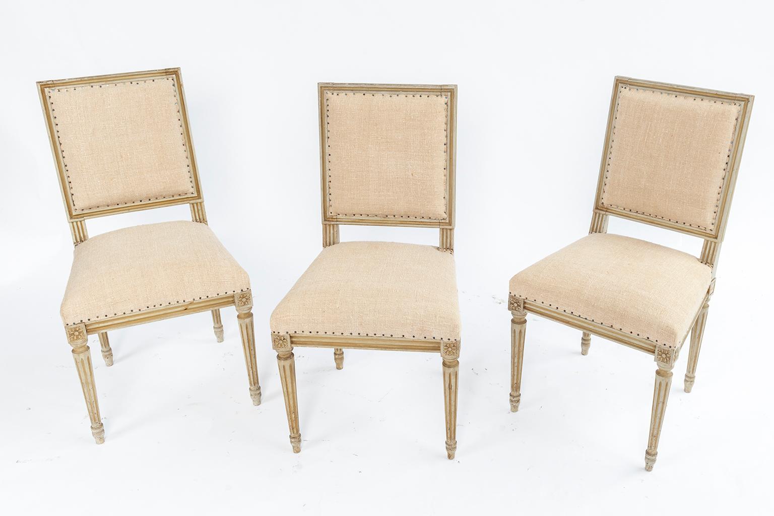 Set of six Louis XVI style square back dining chairs with star Rosettes.
Fluted and reeded legs. New French nailhead upholstery.