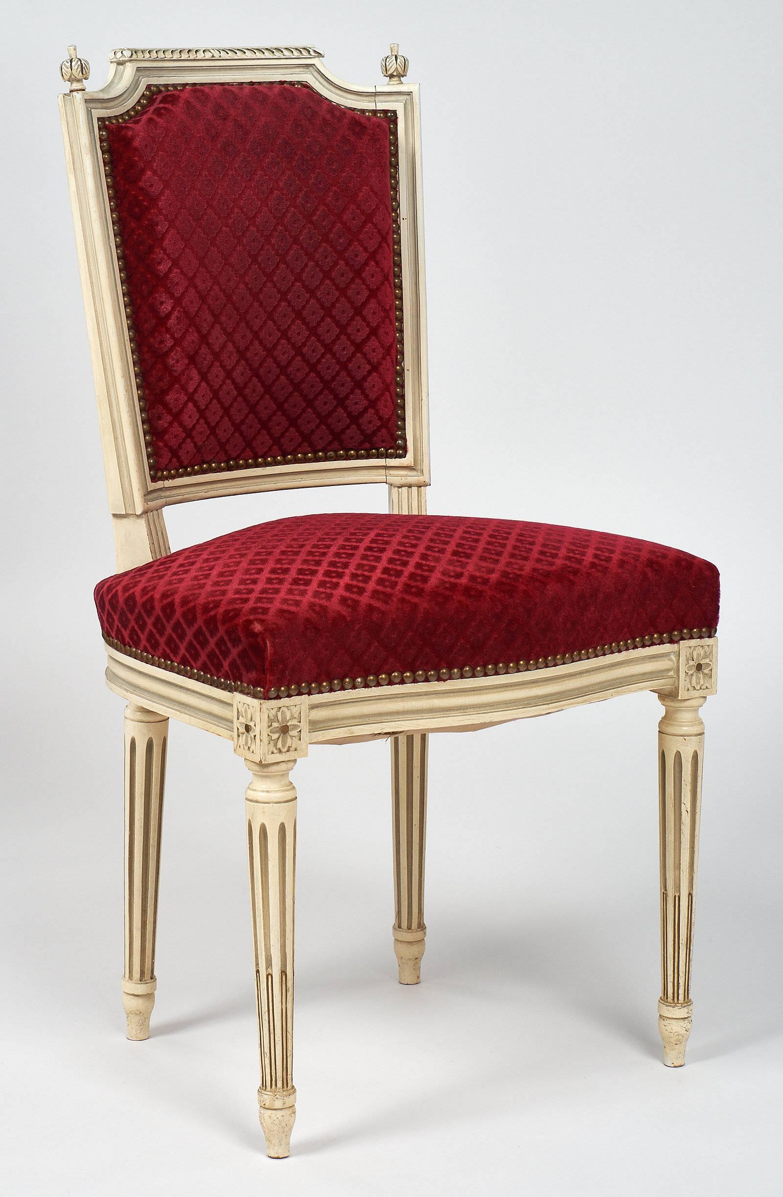 A set of six Louis XVI style velvet dining chair from France with their original paint and upholstery. They have a very strong structure and are in excellent antique condition. We loved the crisp, hand-carved details, and the brass nailheads