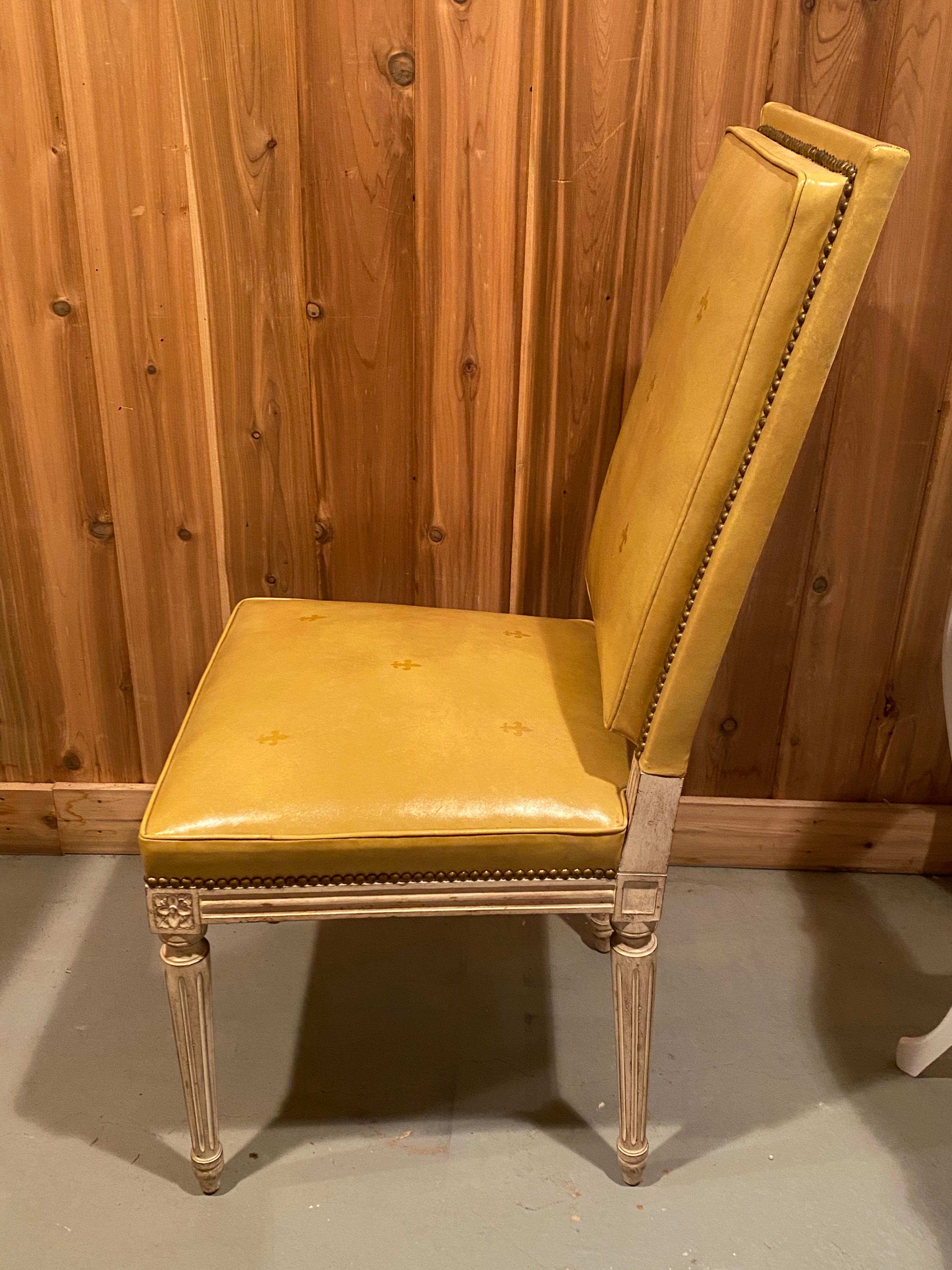 1920s set of six Louis XVI style leather upholstered dining chairs by Fine Arts Furniture Inc. NYC. Beautiful dining chairs upholstered in a yellow leather that wraps both the front and the back of the chairs as well as the seat. With gilt embossed