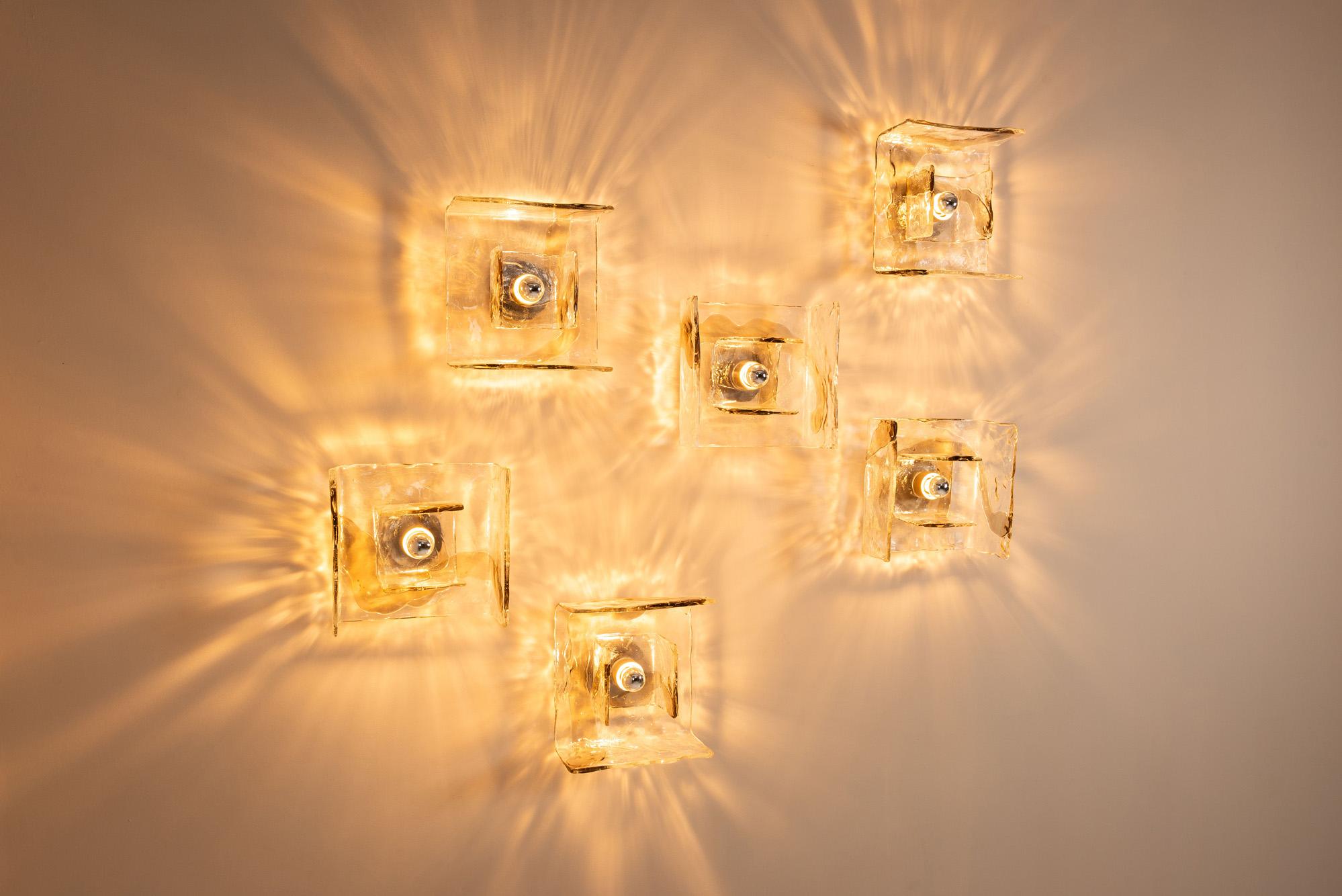 Estudio poético de luz y textura, este raro conjunto de seis apliques de pared LP 257 de Carlo Nason encarna el espíritu experimental del diseño de iluminación italiano de los años setenta. Fabricados por Mazzega, una fábrica de cristal de Murano