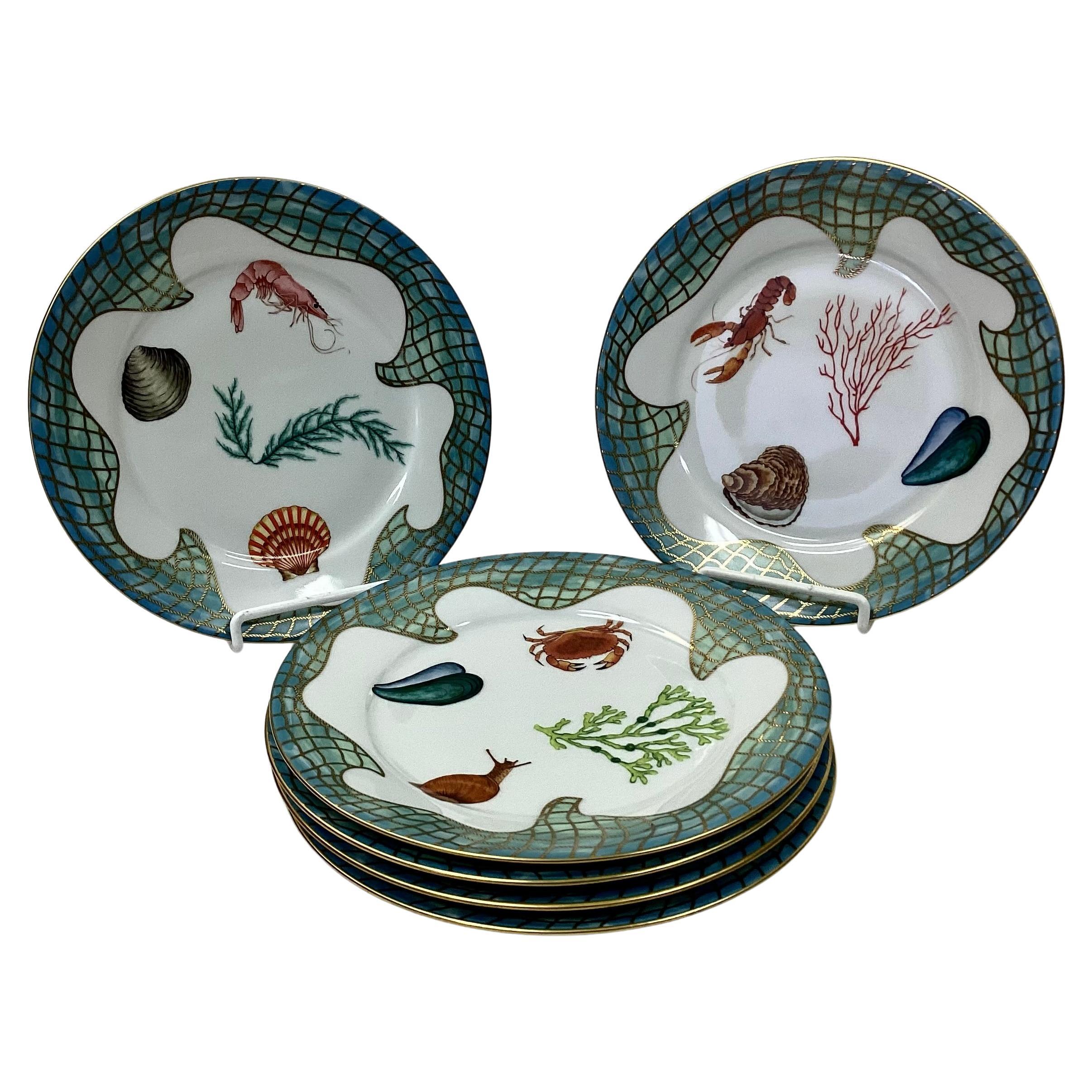 Set of Six (6) Lynn Chase Saint Tropez Porcelain salad plates. These unique plates are decorated with sea life and oceanic themes accented with 24K gold. Each plate design includes shrimp, crawfish, shells and coral surrounded by painted blue-green