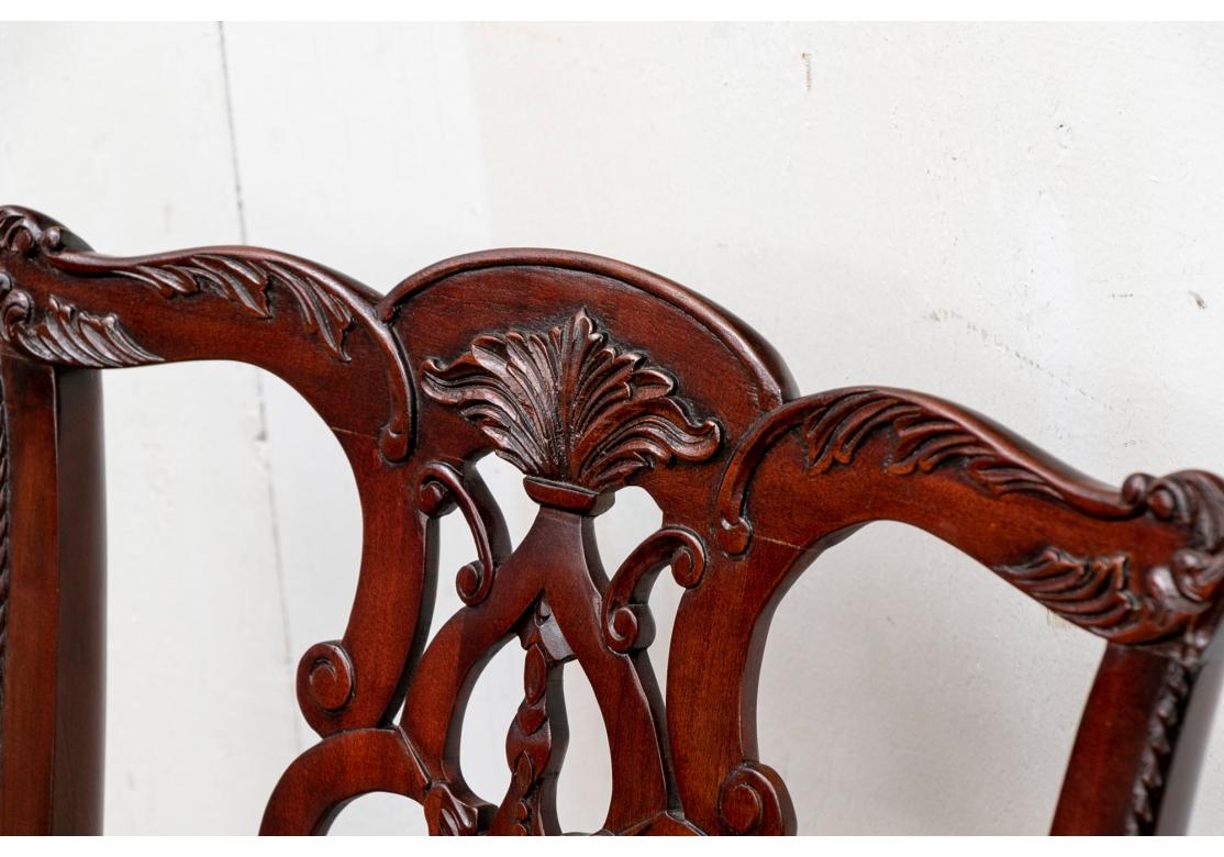 Made in Indonesia. Including two arm and four side chairs. The shaped crest rails with leafy trim, three part scrolled splats with carved leaves on the top. Raised on square legs with H and back stretchers. With cream moire type fabric upholstered