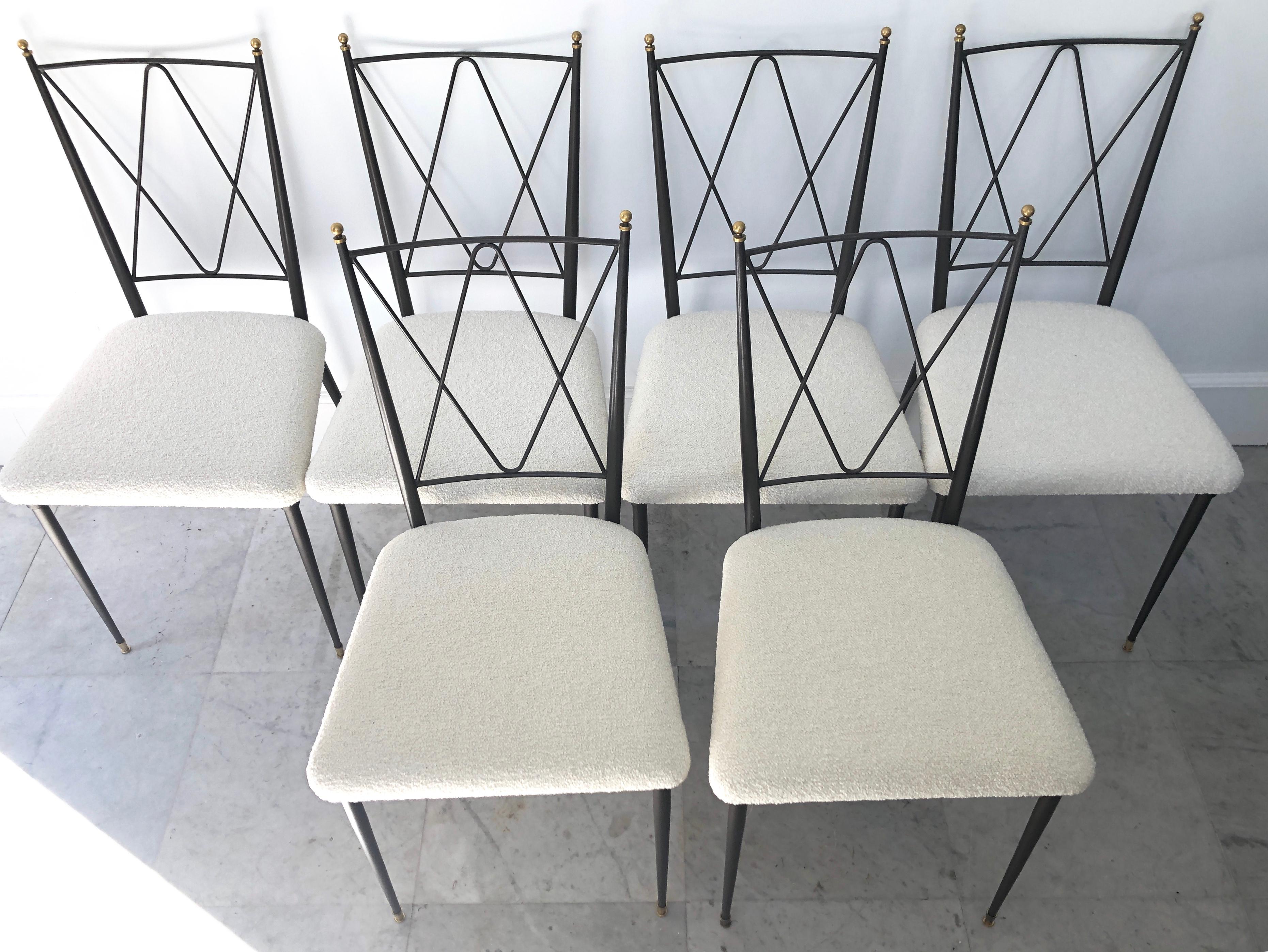 This elegant set of six dining chairs is attributed to Maison Jansen, circa 1940. The beauty of this set is in the details, galvanized metallic delicate brass accents, warm touches of golden metal, and a creamy, bouclé Bergamo fabric by Bisson