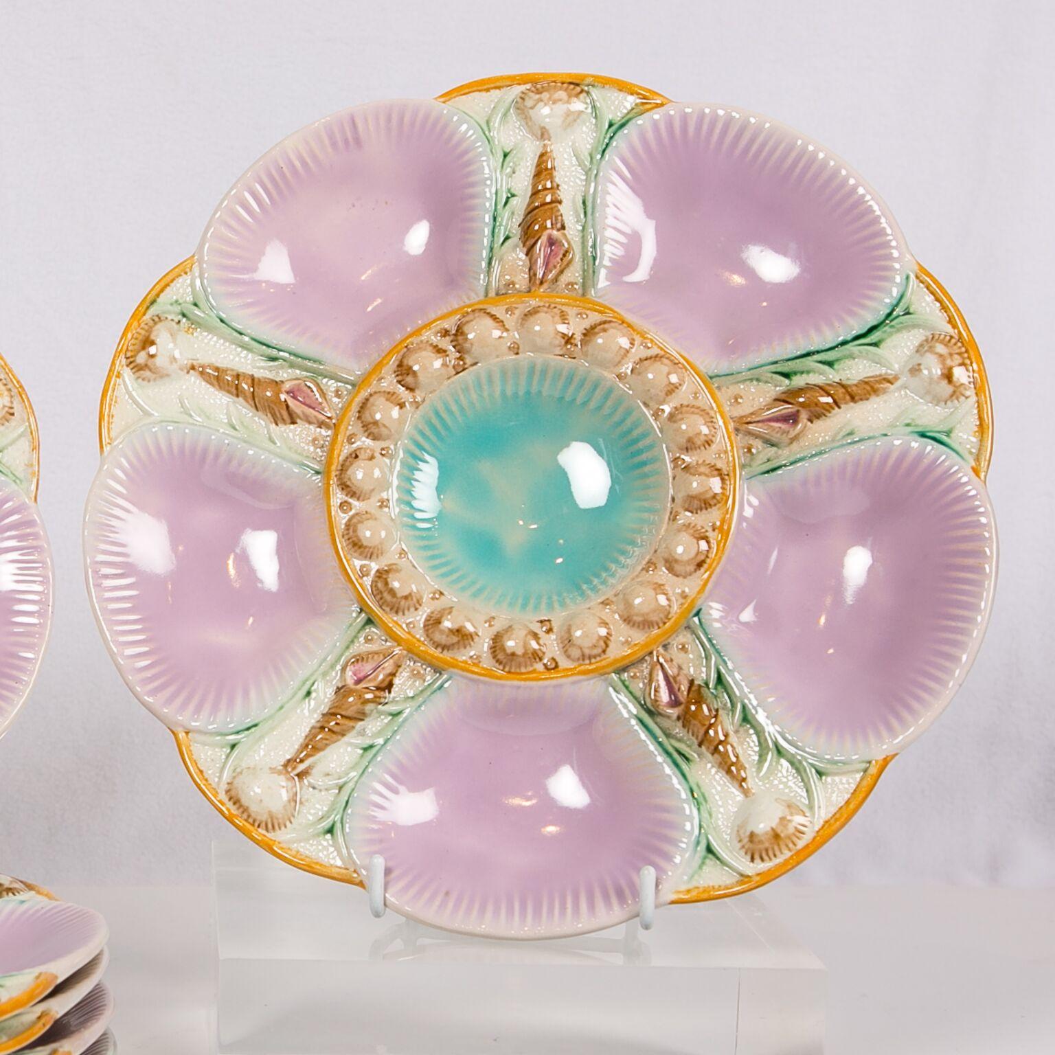A set of six majolica oyster plates with shells between each purple/pink oyster cup and surrounding the turquoise center cup. Made in England circa 1880 they measure 9.75