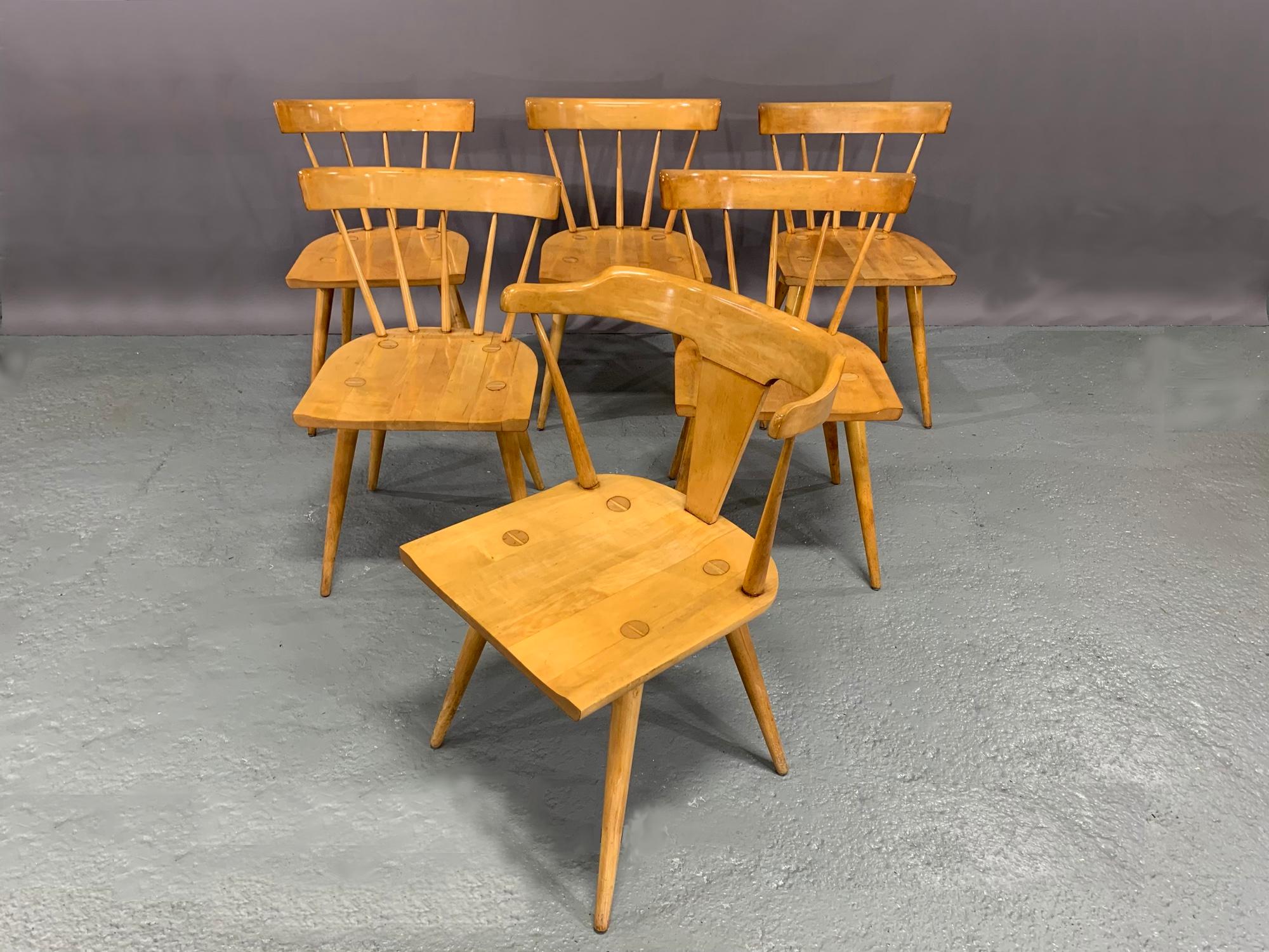 Set of six Mid-Century Modern, maple dining chairs designed by Paul McCobb for the Planner Group collection of the Winchendon Furniture Company. The set consists of five (5) side chairs and one (1) head-of-the-table Captain's armchair. Paul McCobb