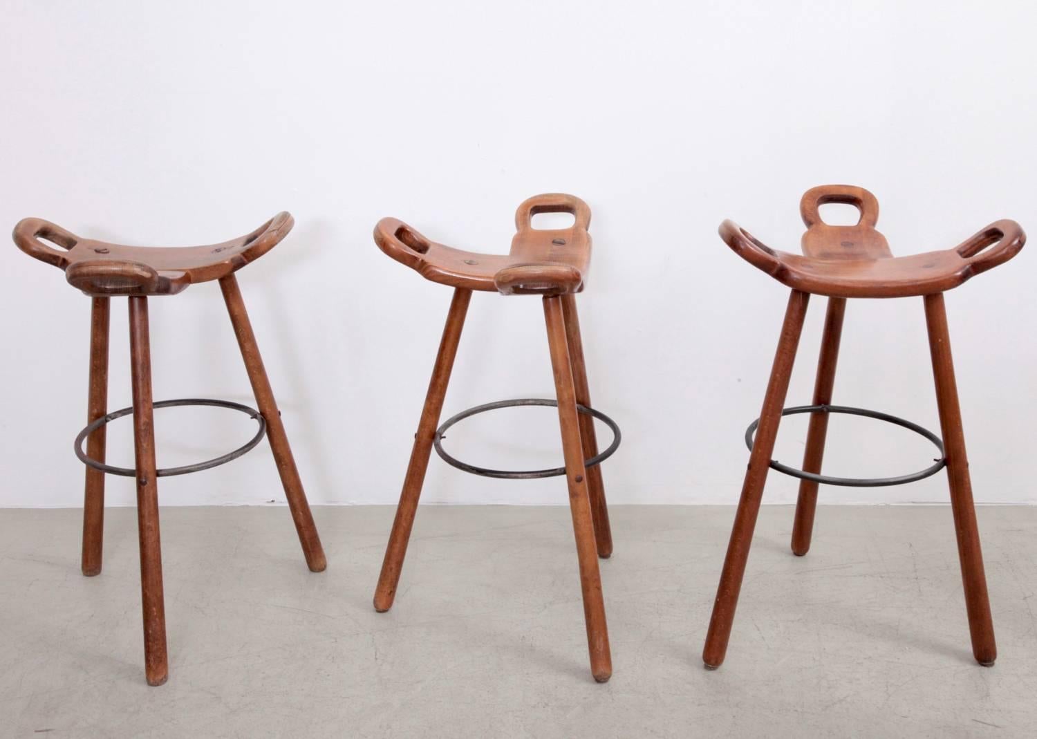 Set of six 'Brutalist' or 'Marbella' bar stools, in stained beech and metal, Spain, 1970s. 

Set of six Brutalist bar stools in brown stained beech. The eye-catching part is the seating. A curved T-shape with three handles. The handles are not