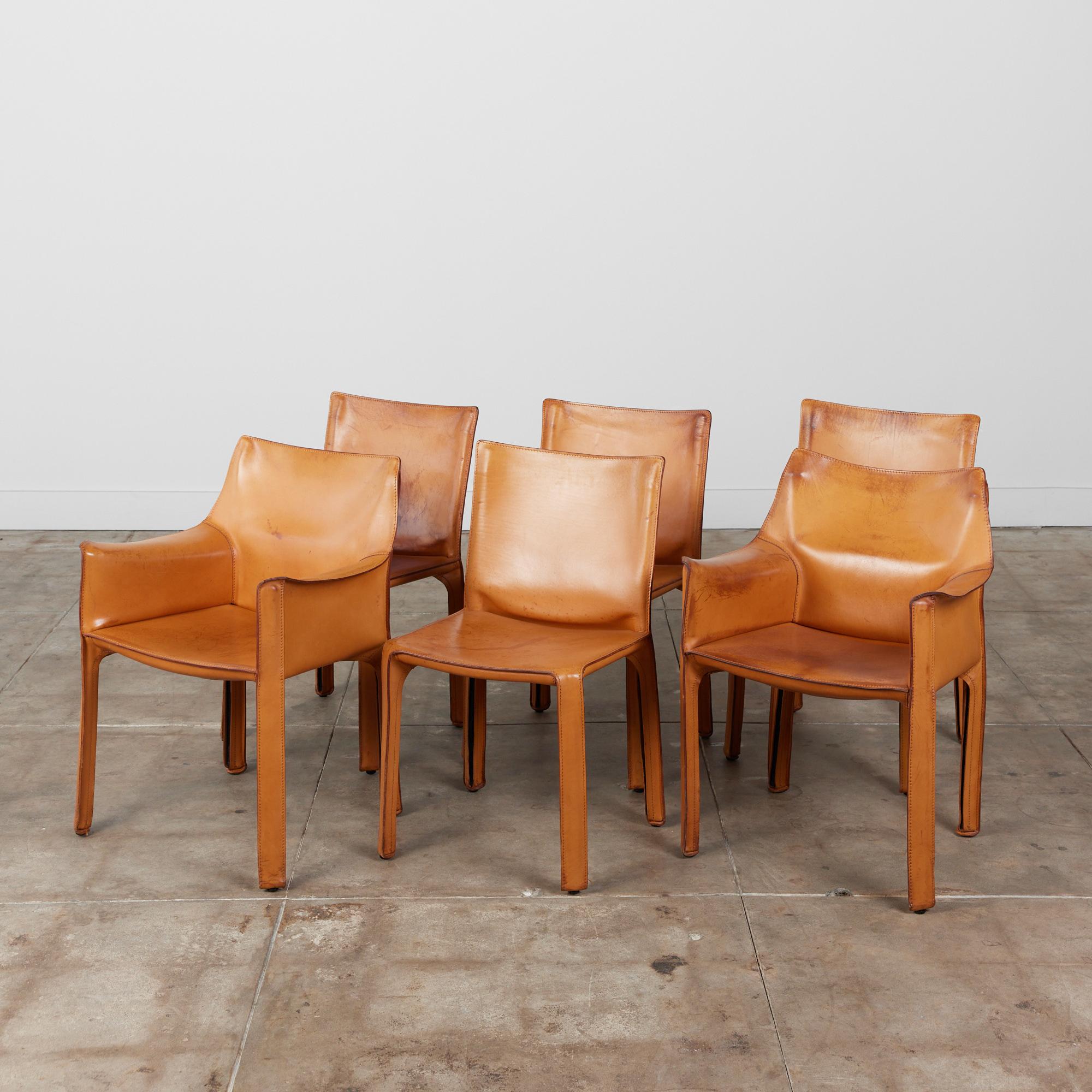 The iconic chairs designed by Mario Bellini for Cassina, circa 1970s, Italy, feature the original camel saddle leather which is wrapped atop the steel frames. This set of six consists of two armchairs and four side chairs. The back legs feature a