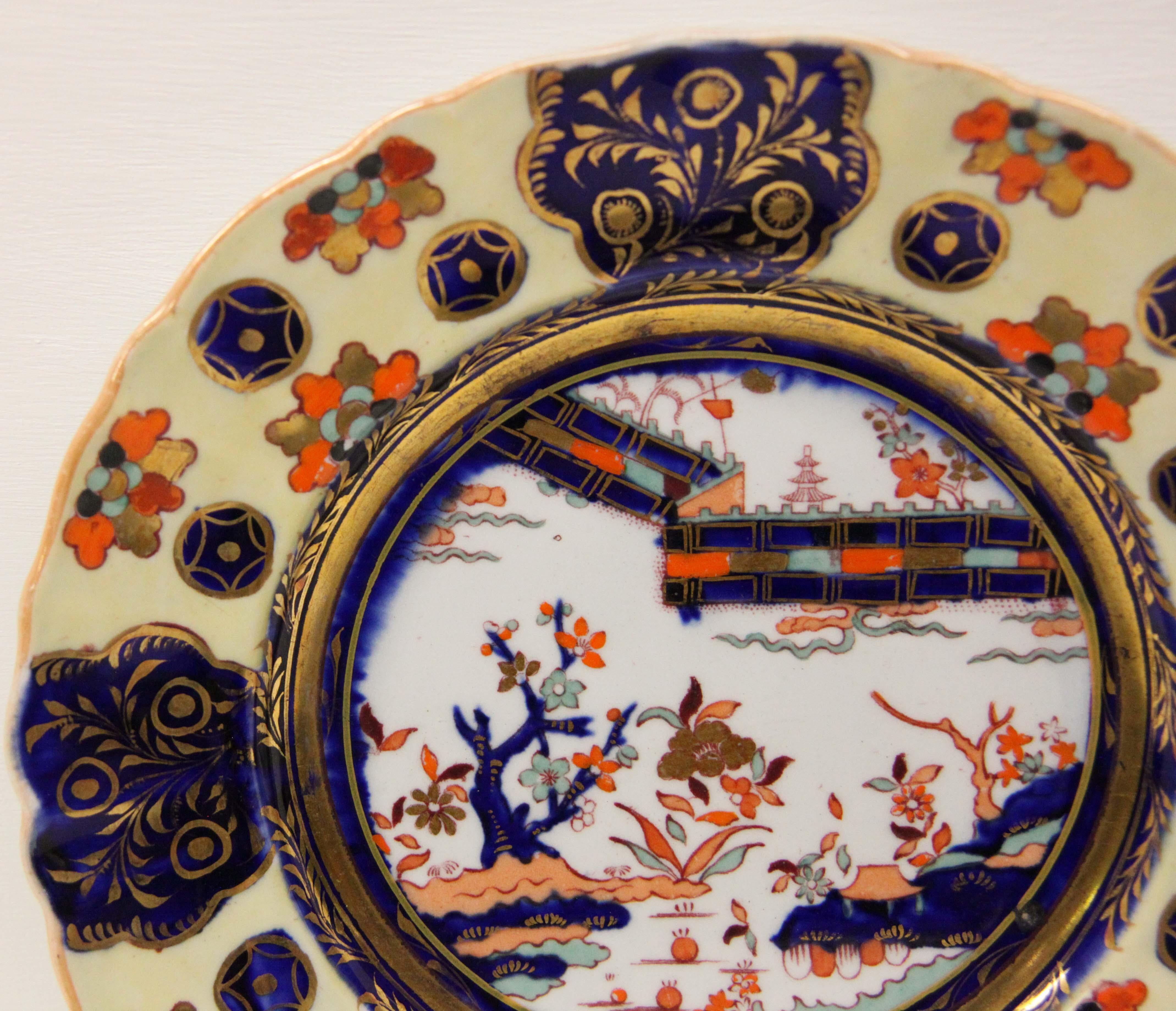 Set of Six Mason's ironstone plates, the light yellow border highlighted with flowers, stylized stars and gilt foliate on a cobalt background, the center with oriental motifs. According to Geoffrey Godden's Encyclopedia of British Pottery and
