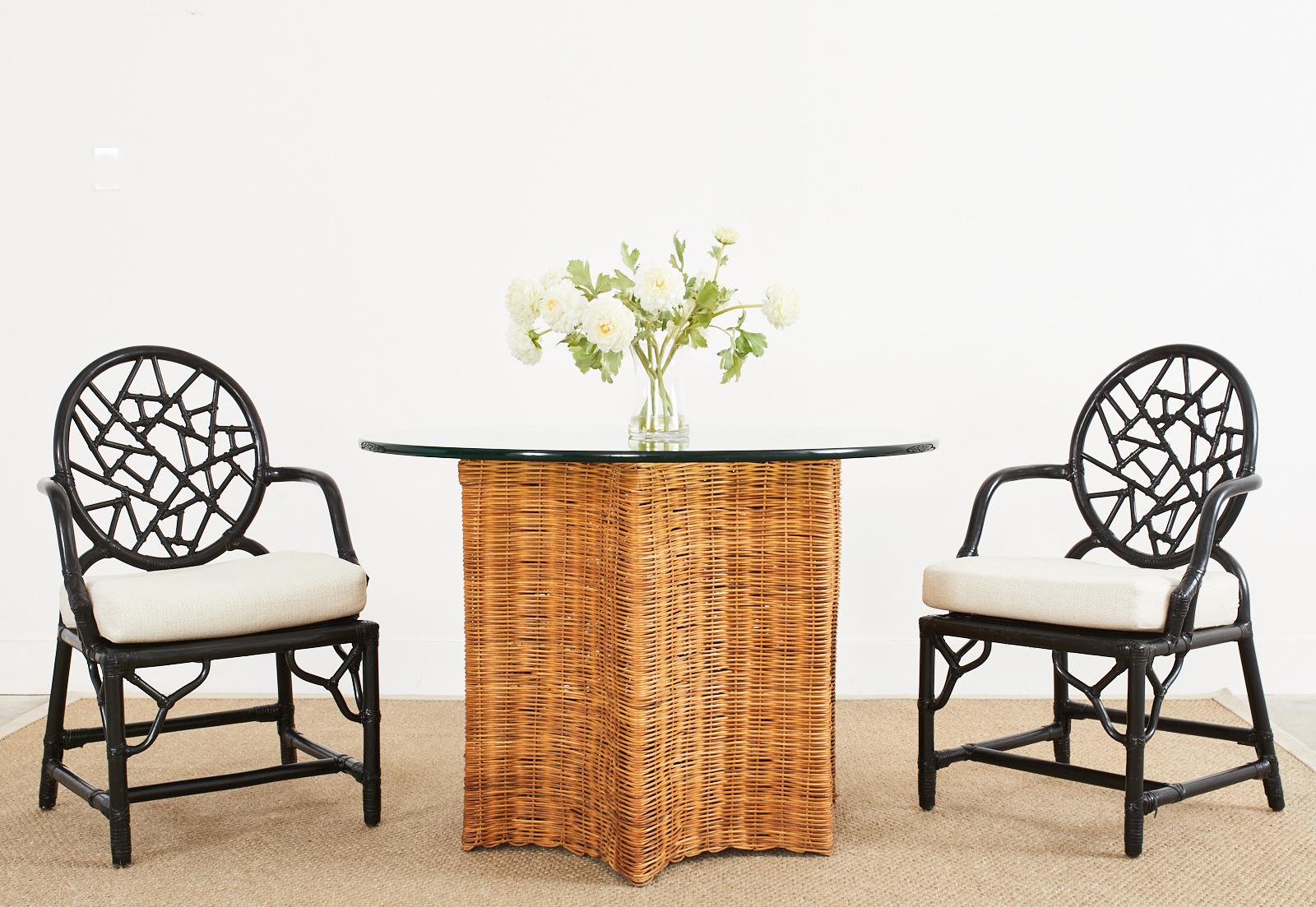 Dramatic set of six black lacquered rattan dining chairs by McGuire. The chairs were designed by Elinor McGuire in 1968 and feature the iconic cracked ice or shattered glass round back crafted from rattan pieces lashed together with rawhide leather